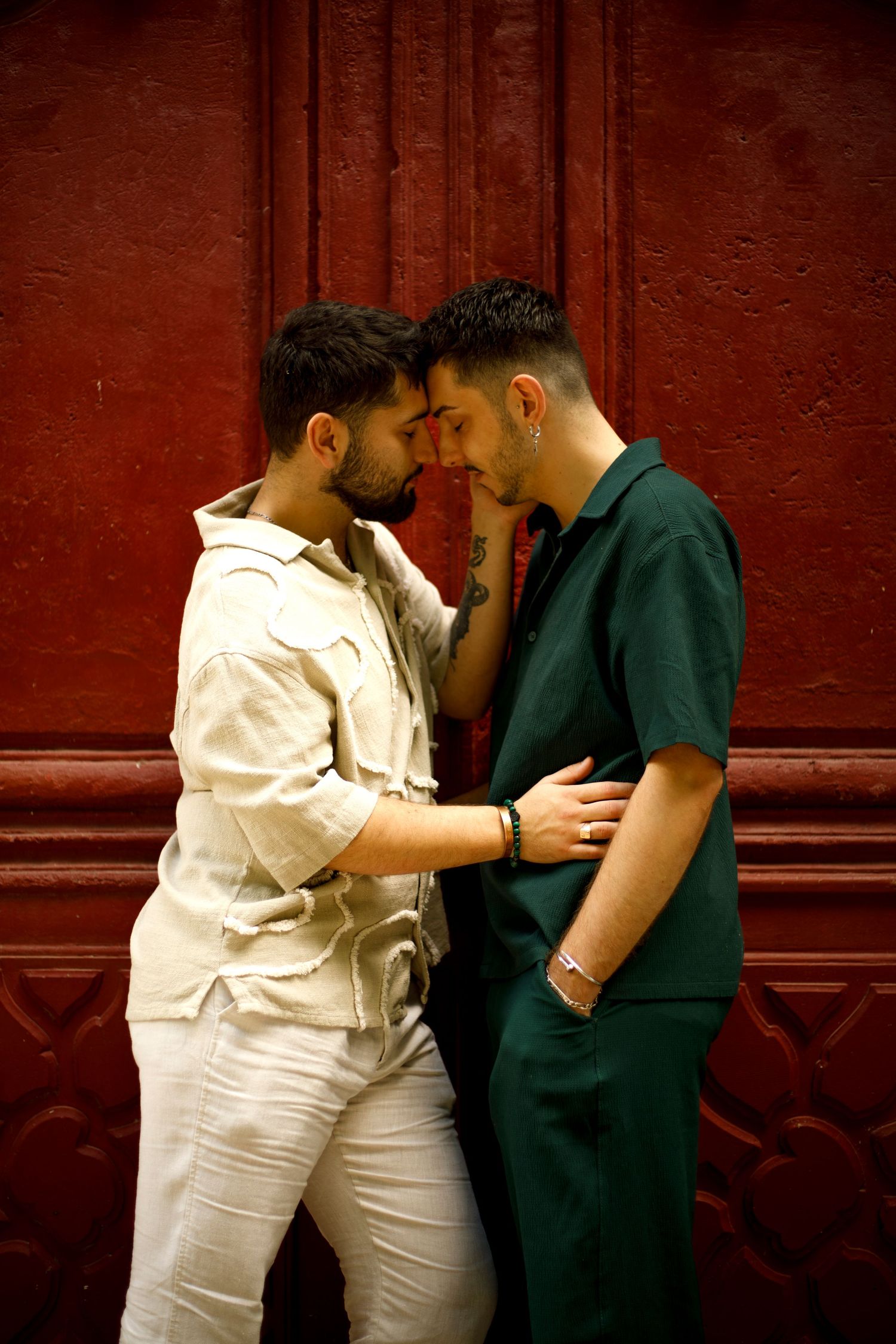 Photo d'un couple gay qui se tiennent front contre front, yeux fermés