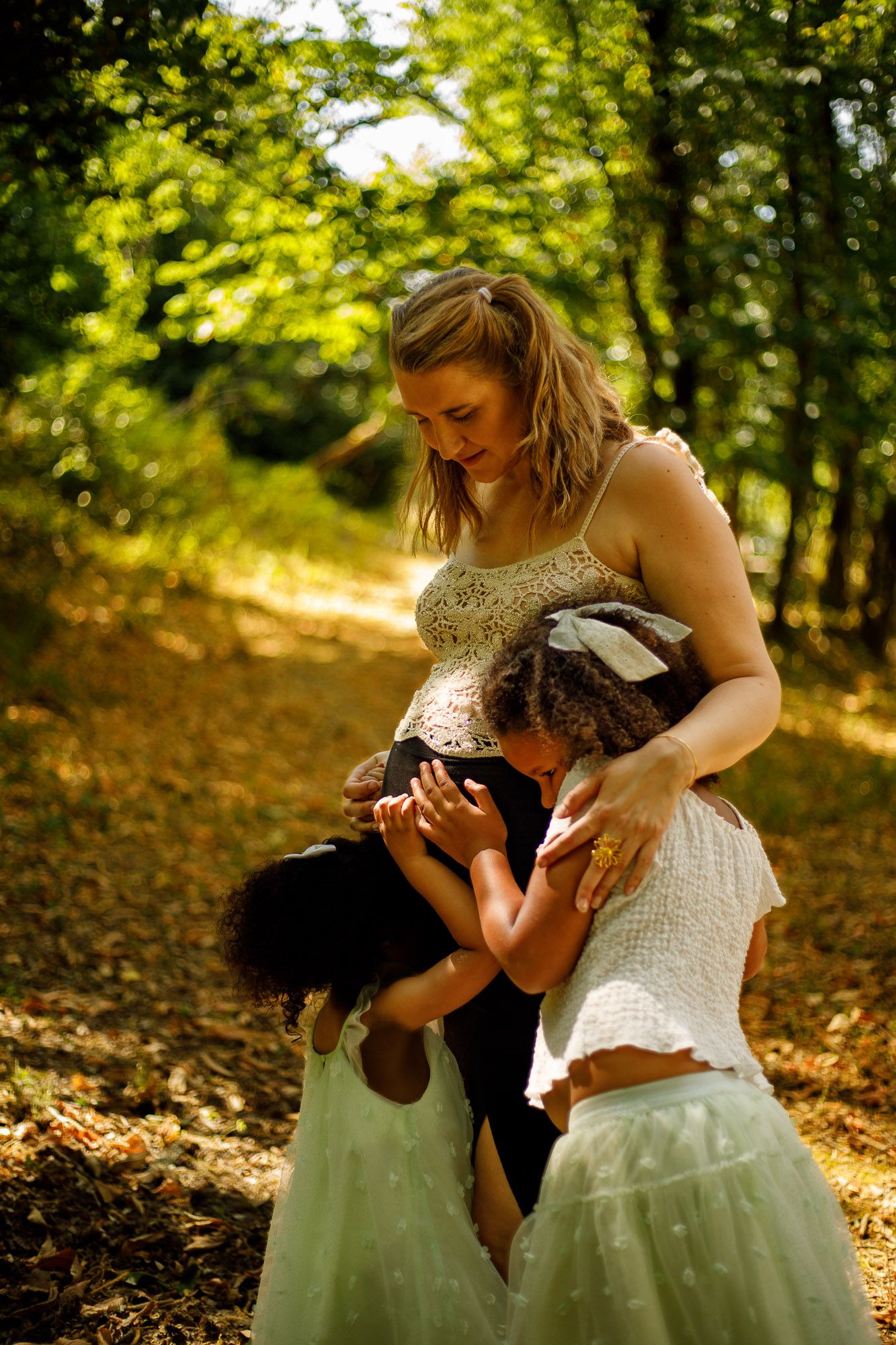 Calin de deux fillettes à leur maman enceinte lors d'une séance grossesse dans le Tarn.