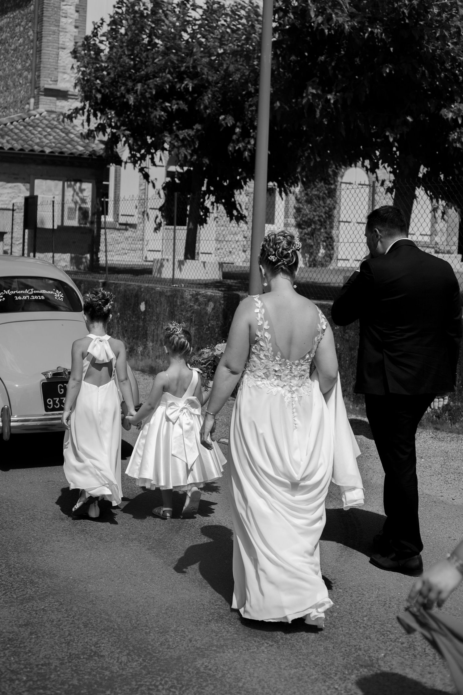 Les mariés et leurs filles marchent en direction de l'église dans leur village du Tarn