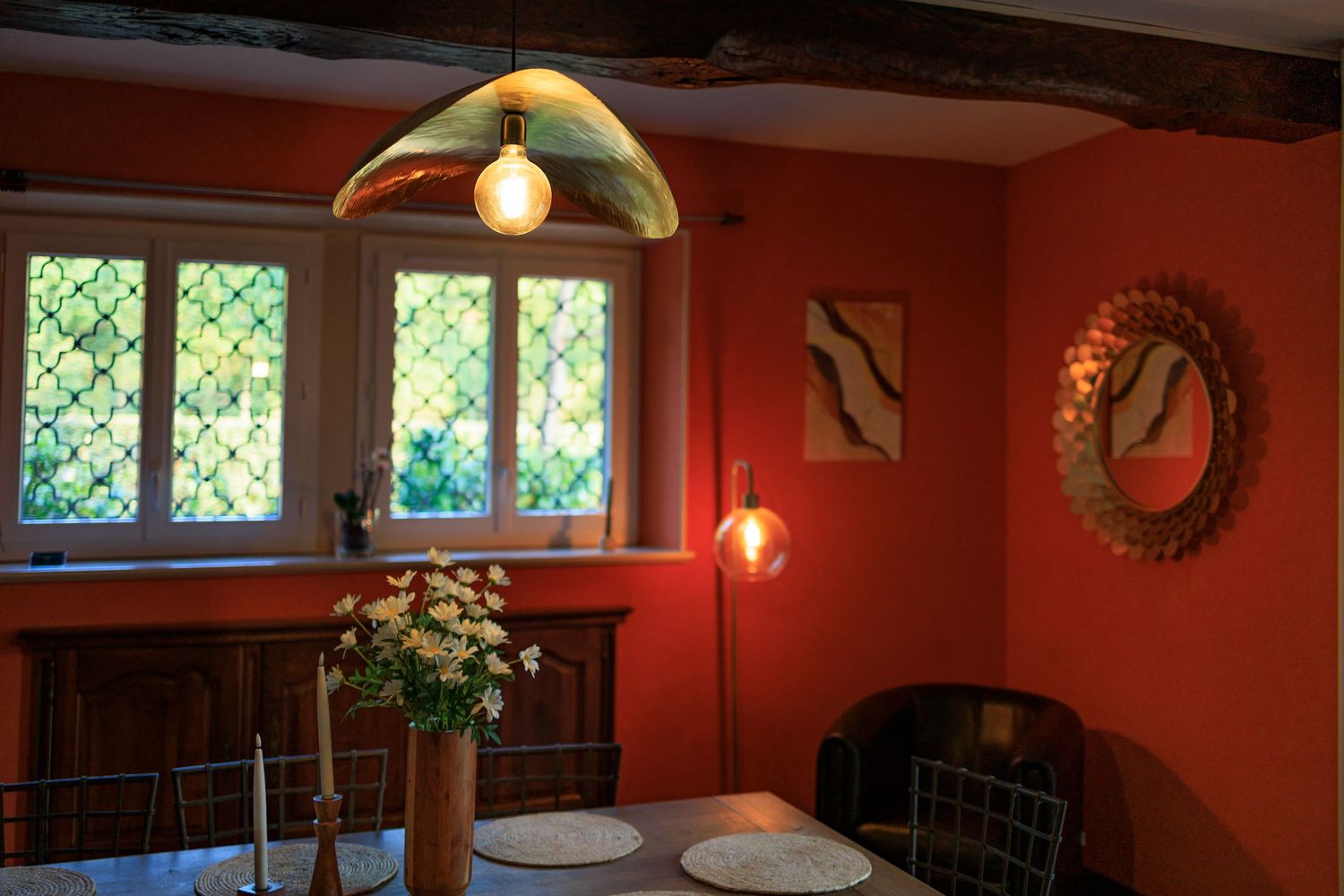 Salle à manger chaleureuse d'un gîte de charme avec murs colorés et luminaires design au Domaine de Hauterive dans le Tarn.