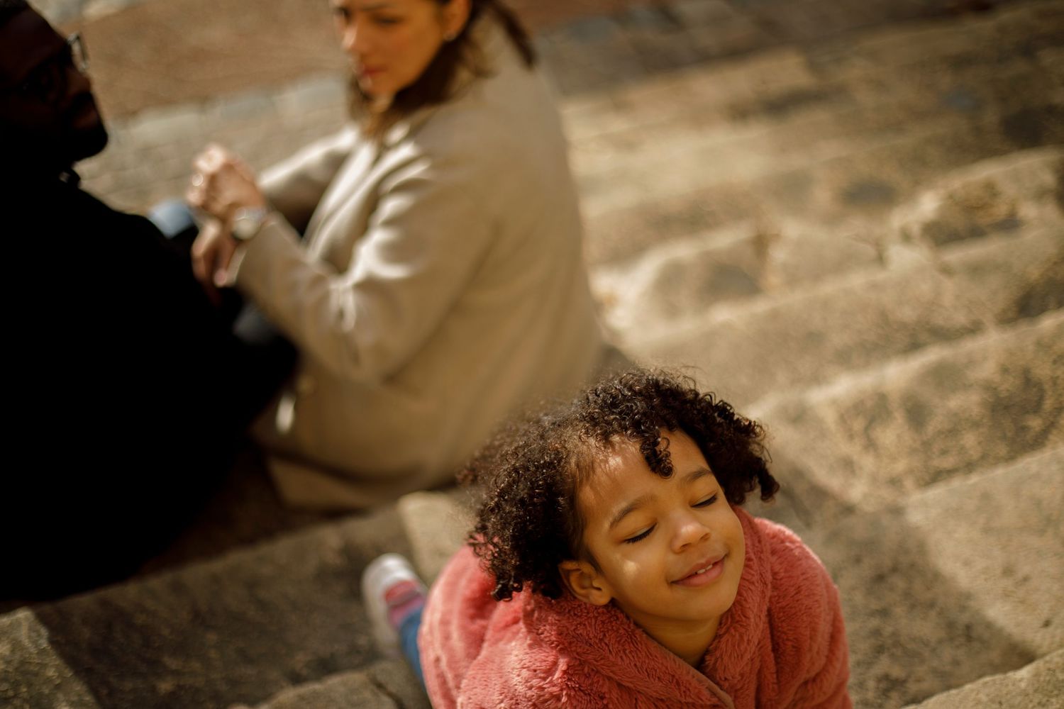 Photo d'une petite fille venant jouer avec l'appareil photo sur les marches de l'Eglise Saint Roch à Montpellier