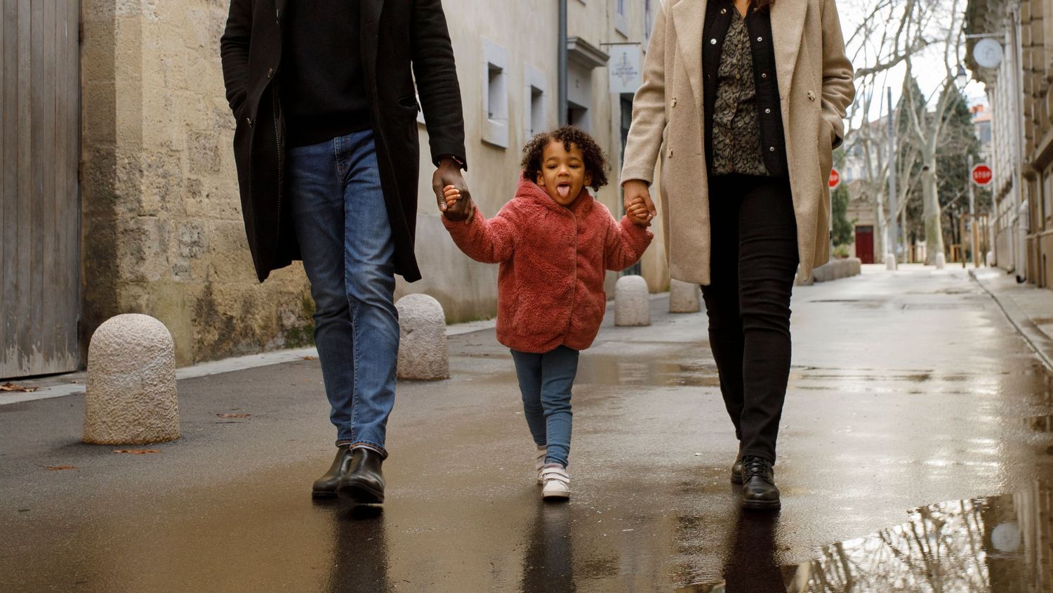 Photographie d'une petite qui tient la main trop fière à ses parents