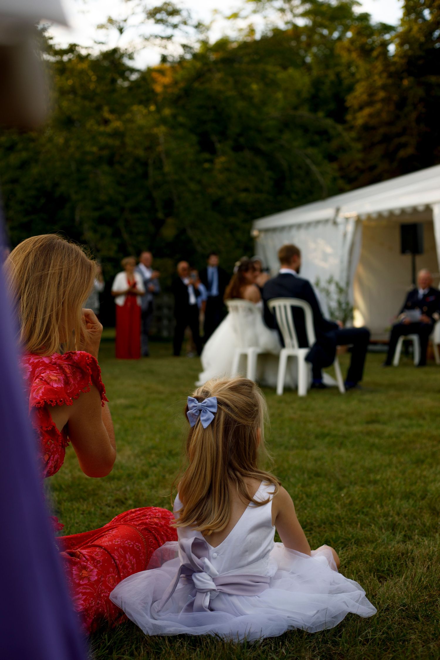Nièce des mariés écoute le discours des parents de la mariée avec attention