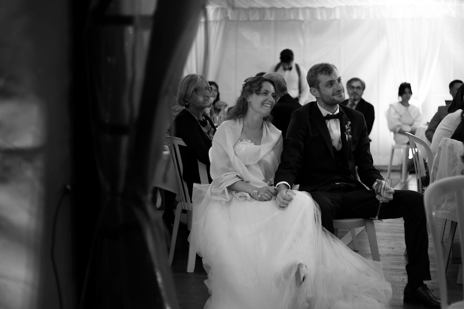 Reportage mariage, Photographie noir et blanc des mariés touchés par le discours de leurs amis