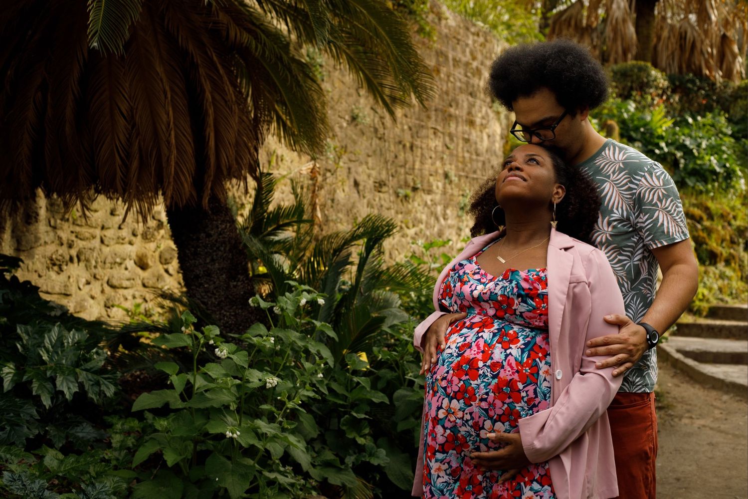 Futurs parents posant amoureusement sous les palmiers lors d'une séance photo grossesse à Montpellier