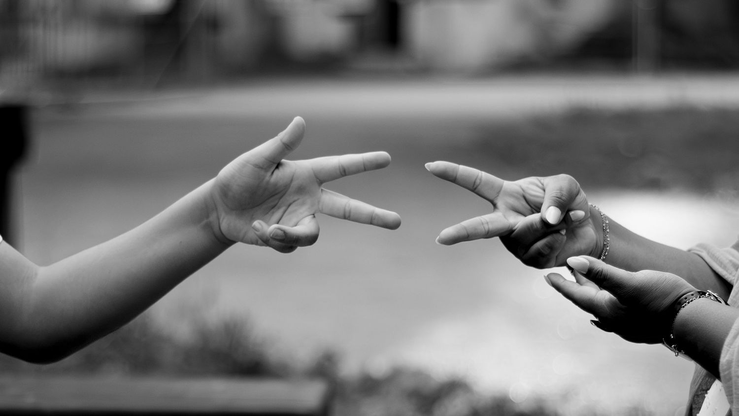 Photo en noir et blanc de deux enfants jouant à pierre-feuille-ciseaux avec leurs mains.