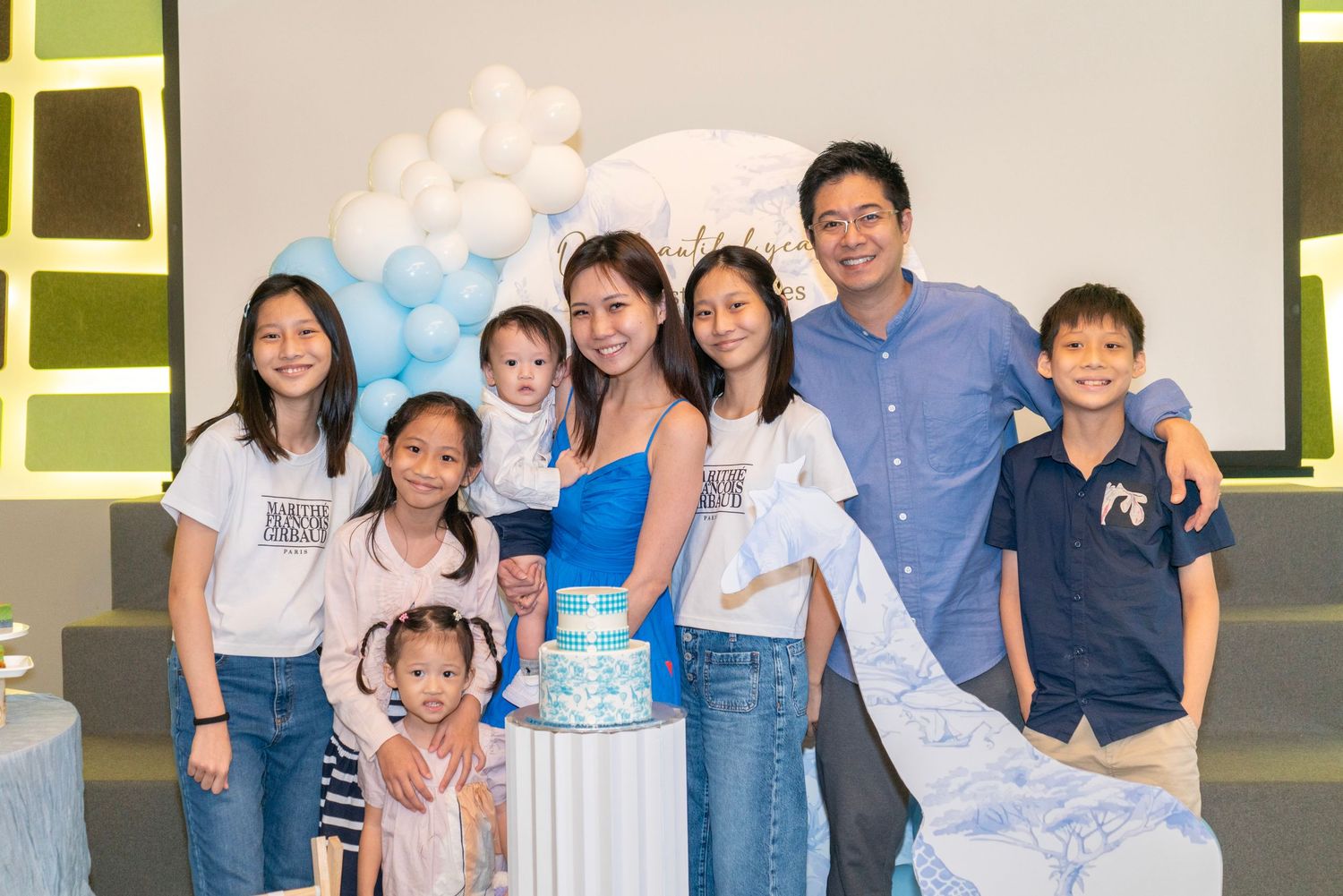 Group photo at a casual gathering with light-colored backdrop.