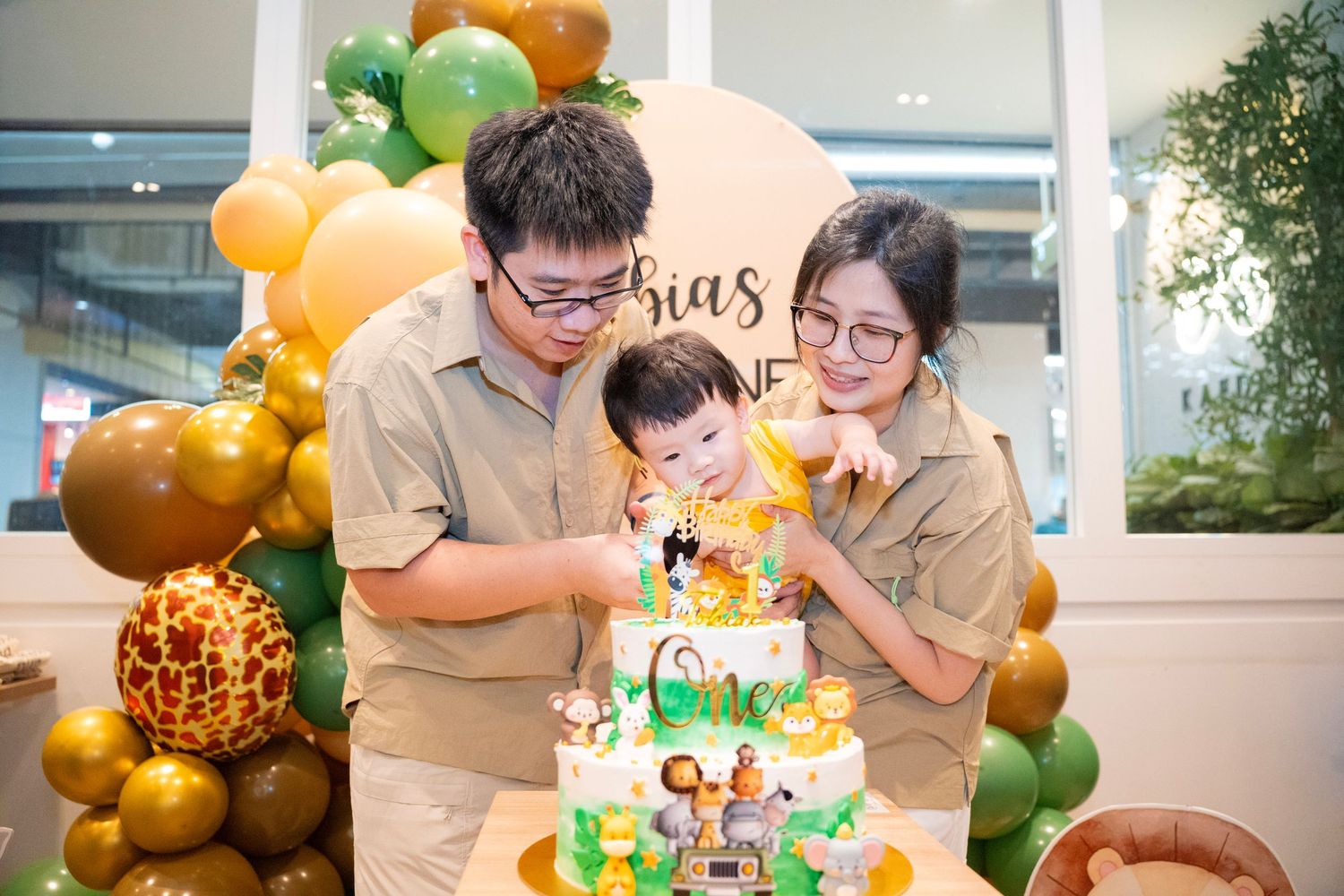 Festive balloon arrangements in gold and green colors with decorative elements for a celebration.