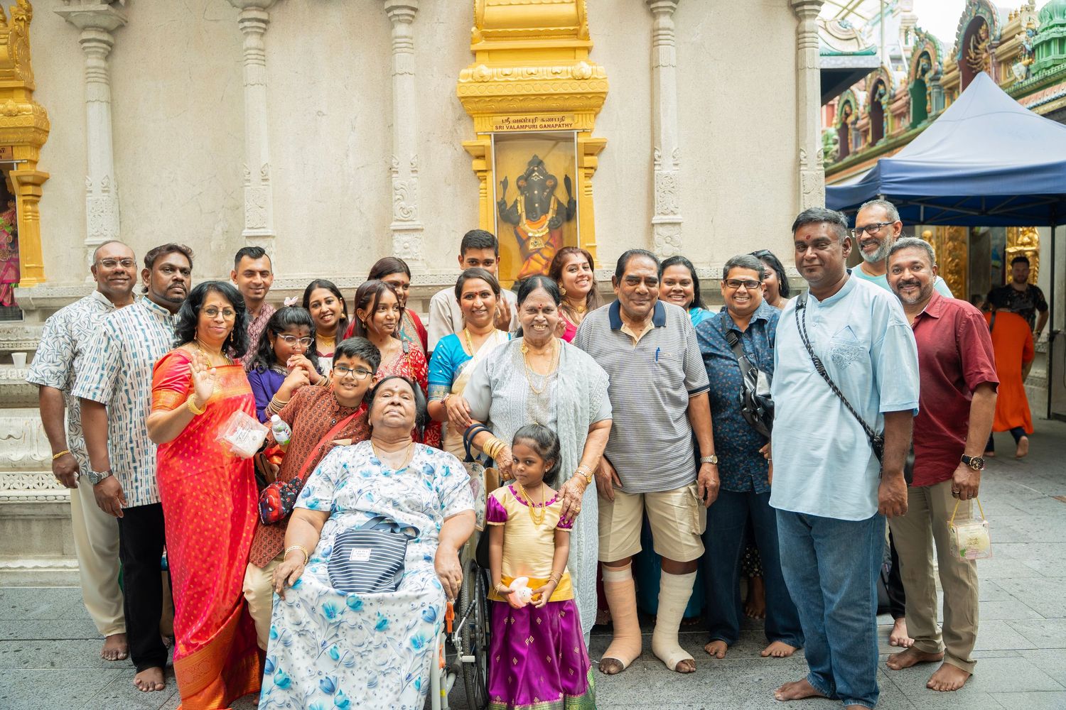 Large group of guests gathered outside a traditional building for a celebration.
