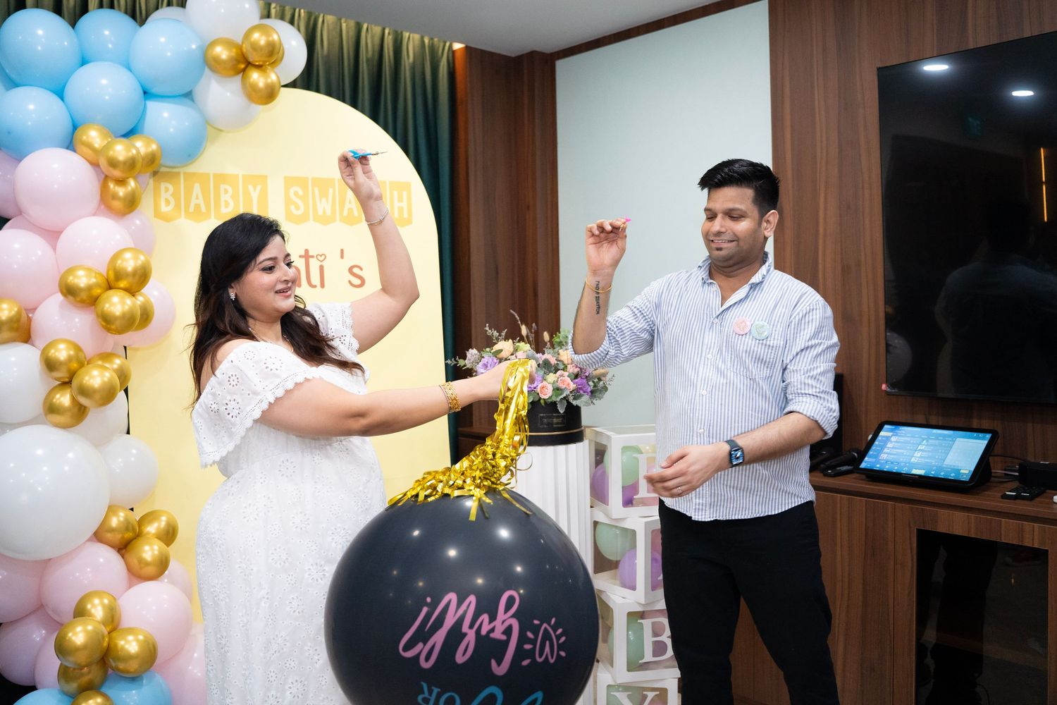 Party celebration with blue and gold balloon decorations in an indoor venue.