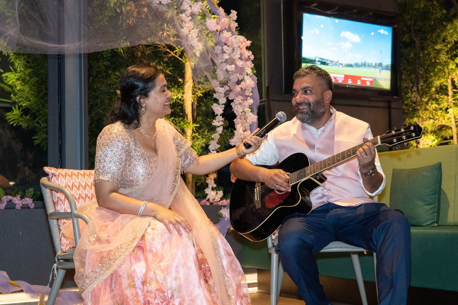 Romantic evening performance with acoustic guitar on decorated set with floral arrangements.