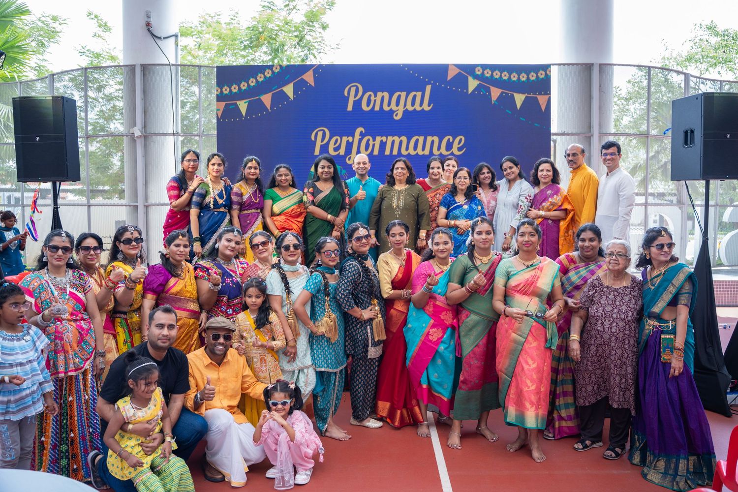 Traditional cultural gathering with performers in colorful ethnic attire at a community event.