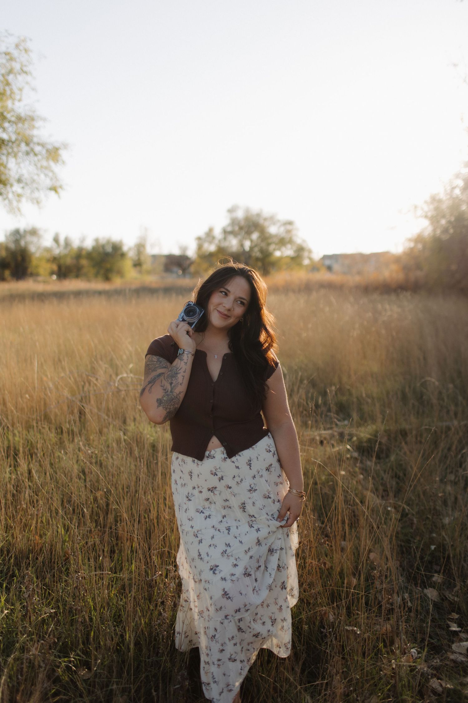 Sunlit outdoor portrait session in a field of tall grass during golden hour.