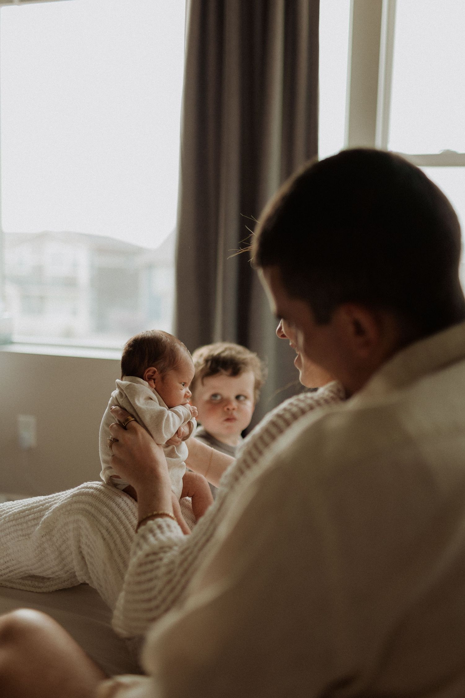 A cozy family moment on the couch with children and soft window light.