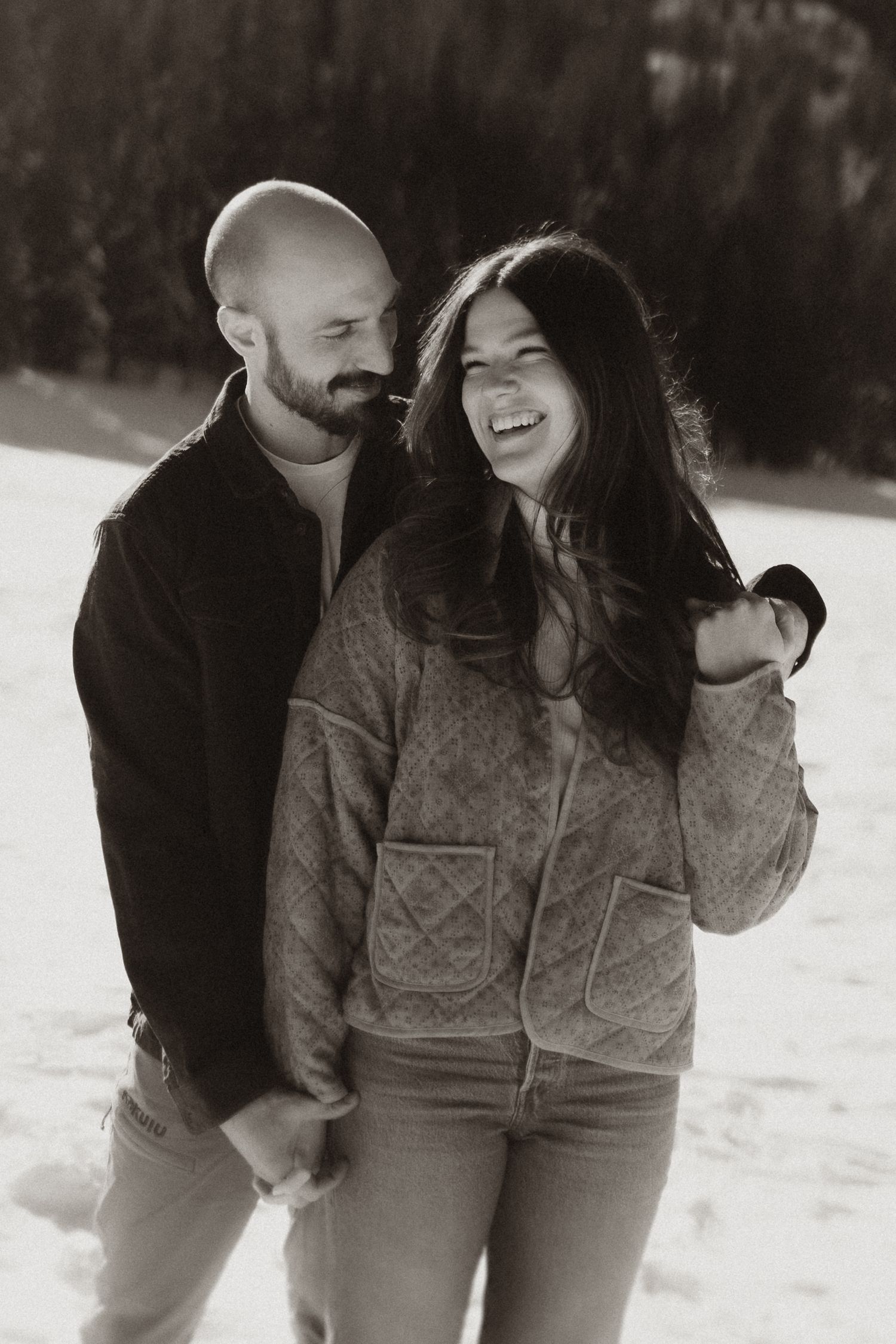 Playful winter couple photos in black and white with snowy background.