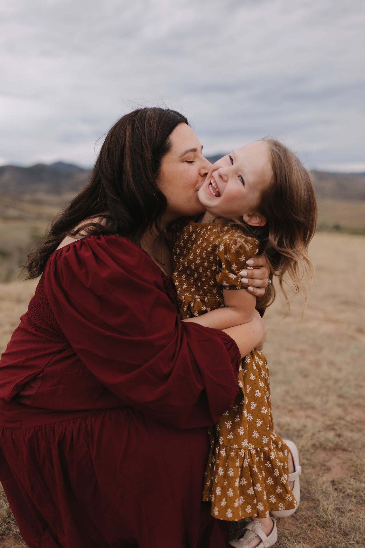 Two people sharing joyful laughter and embraces in a desert landscape.
