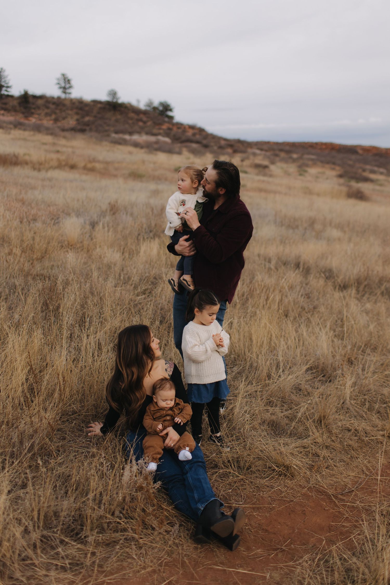 Family portrait session in a rustic field during golden hour.