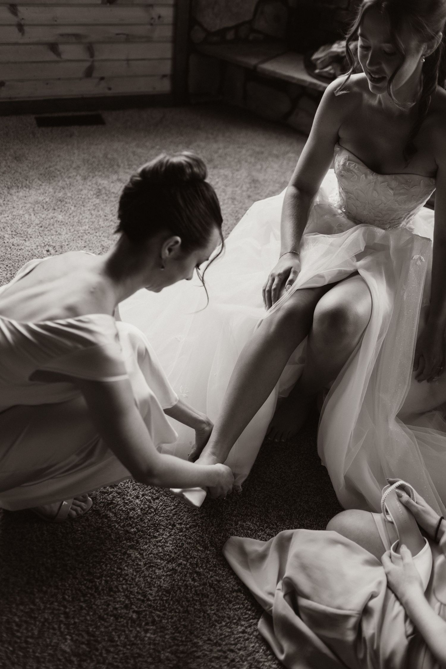 Artistic black and white photo of a flowing white wedding dress against carpet.