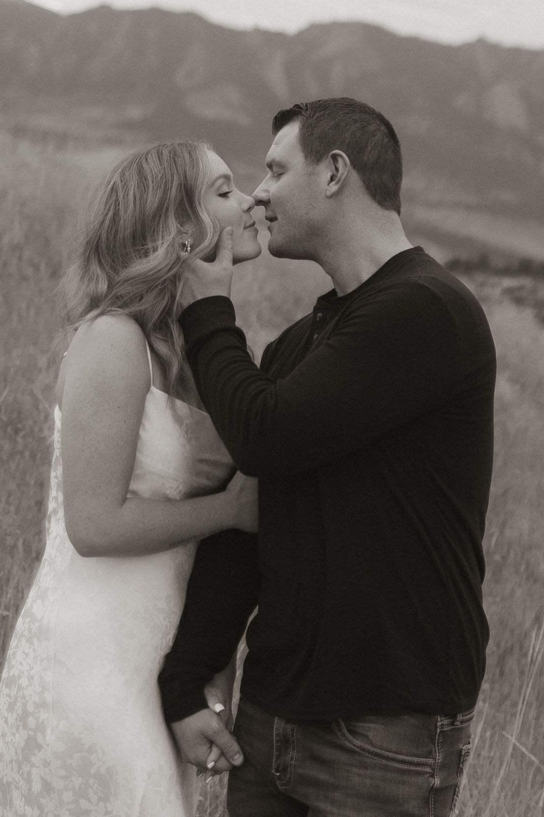 Black and white series of intimate couple portraits in mountain field.