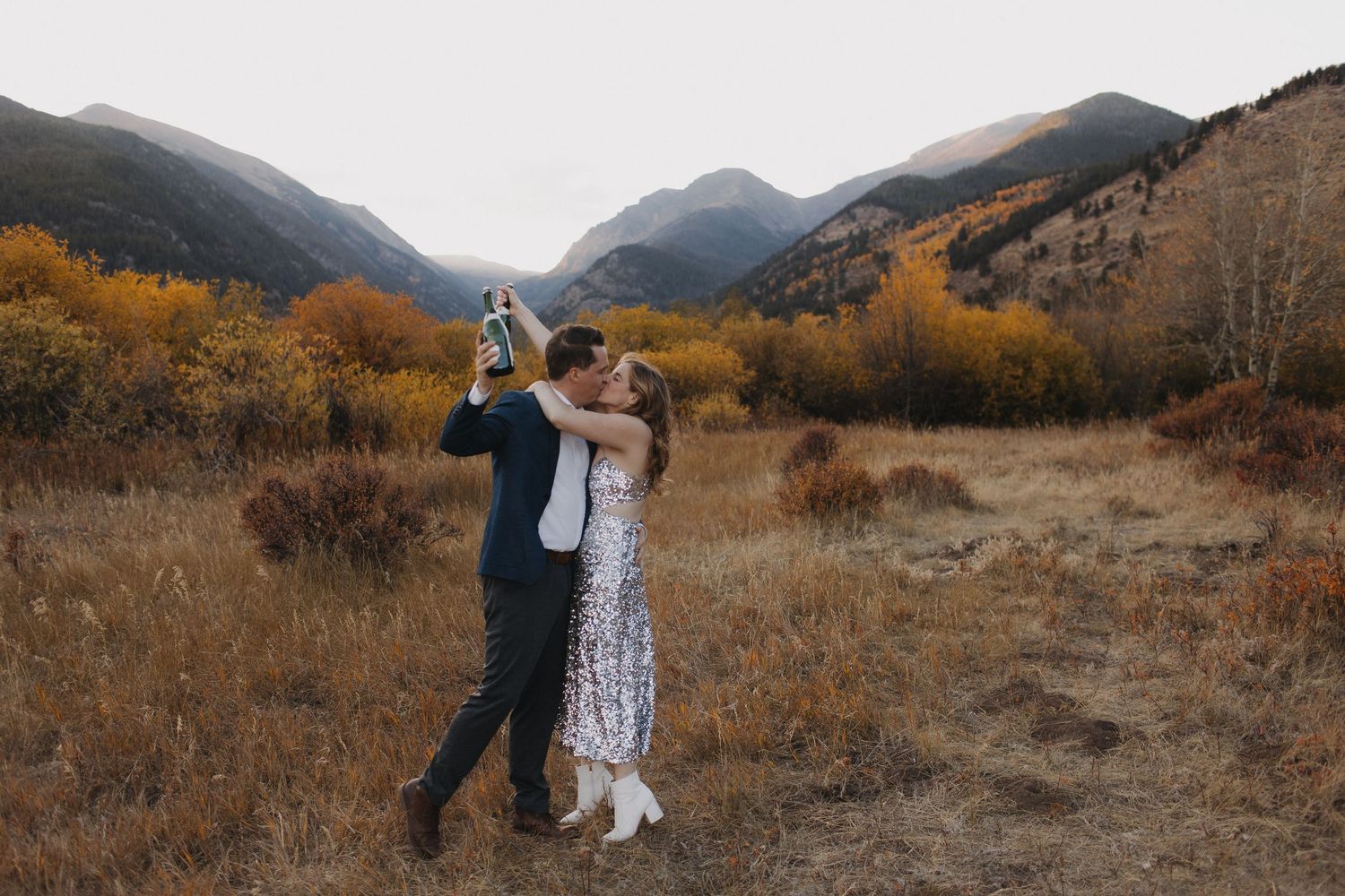 Romantic photoshoot in a mountain valley with autumn colors and distant peaks.