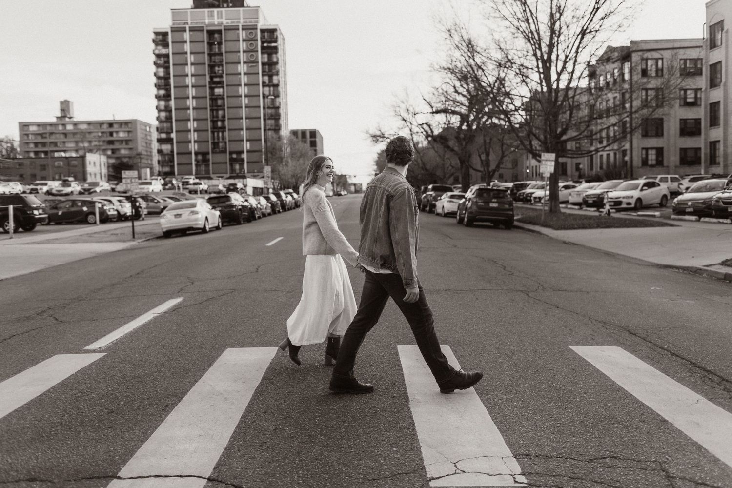 Black and white sequence of people crossing an urban crosswalk in a city street.