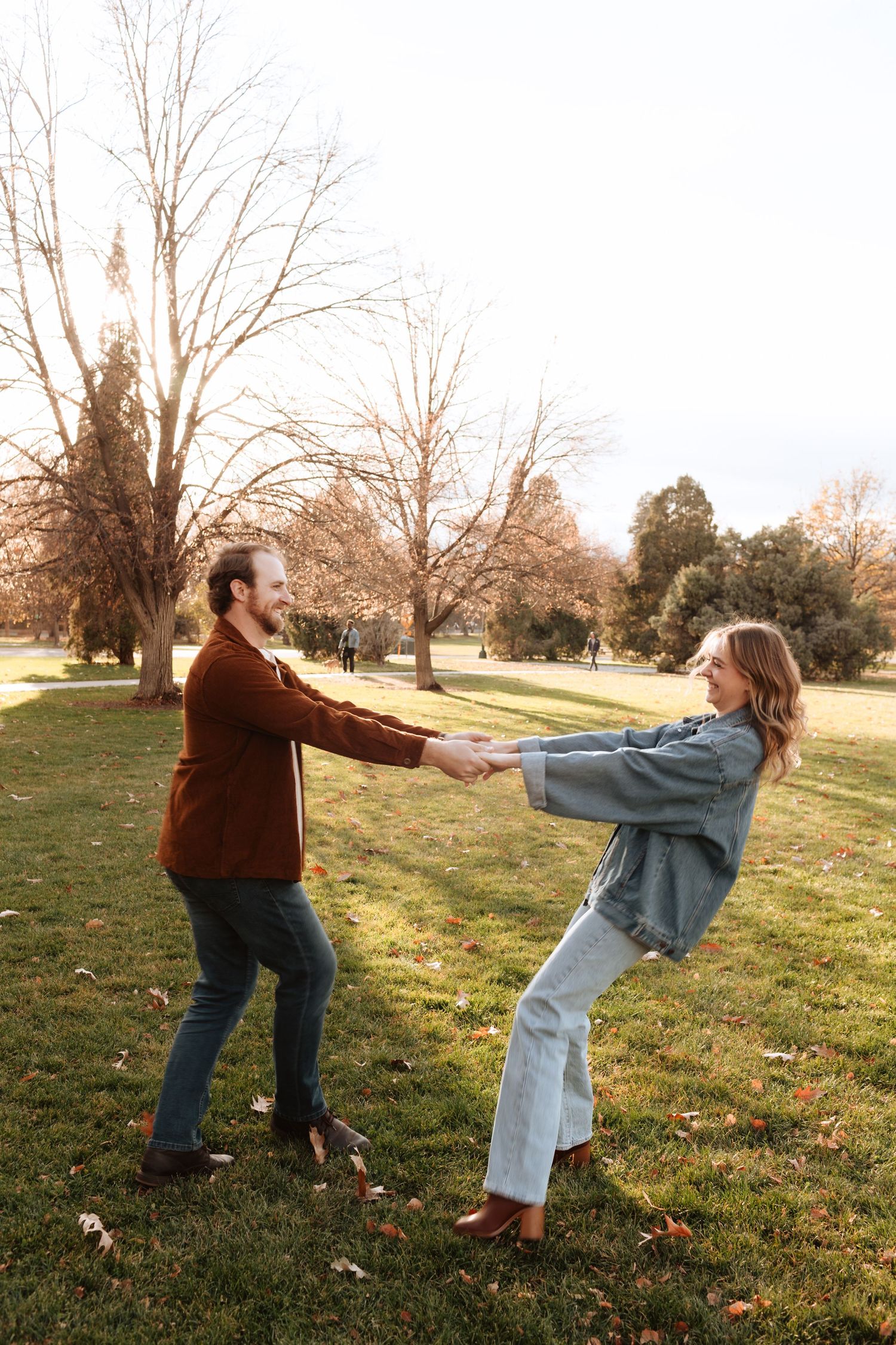 Playful sequence of two people dancing and spinning in a grassy field at sunset.