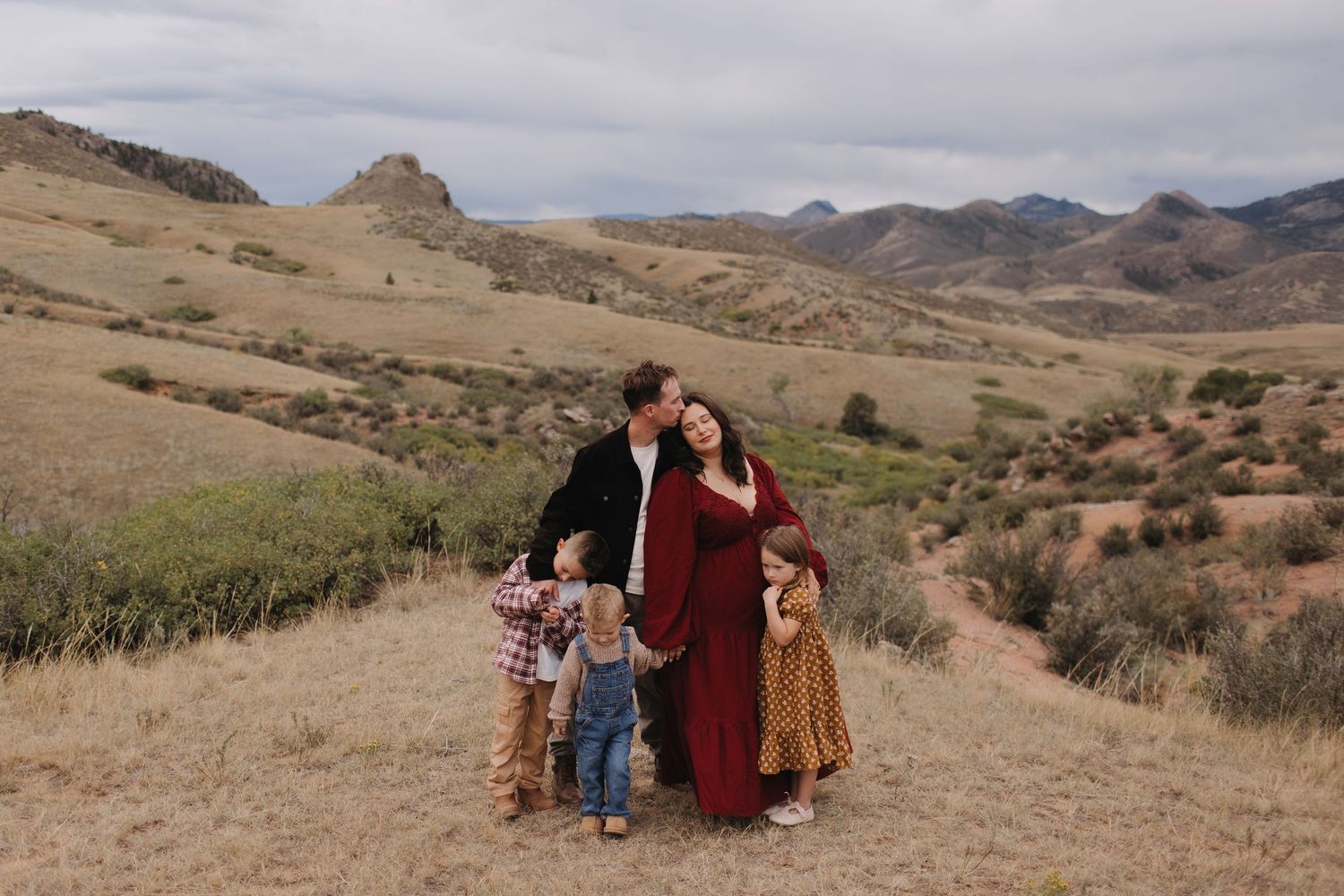 Family portrait session in a scenic mountain landscape during golden hour.
