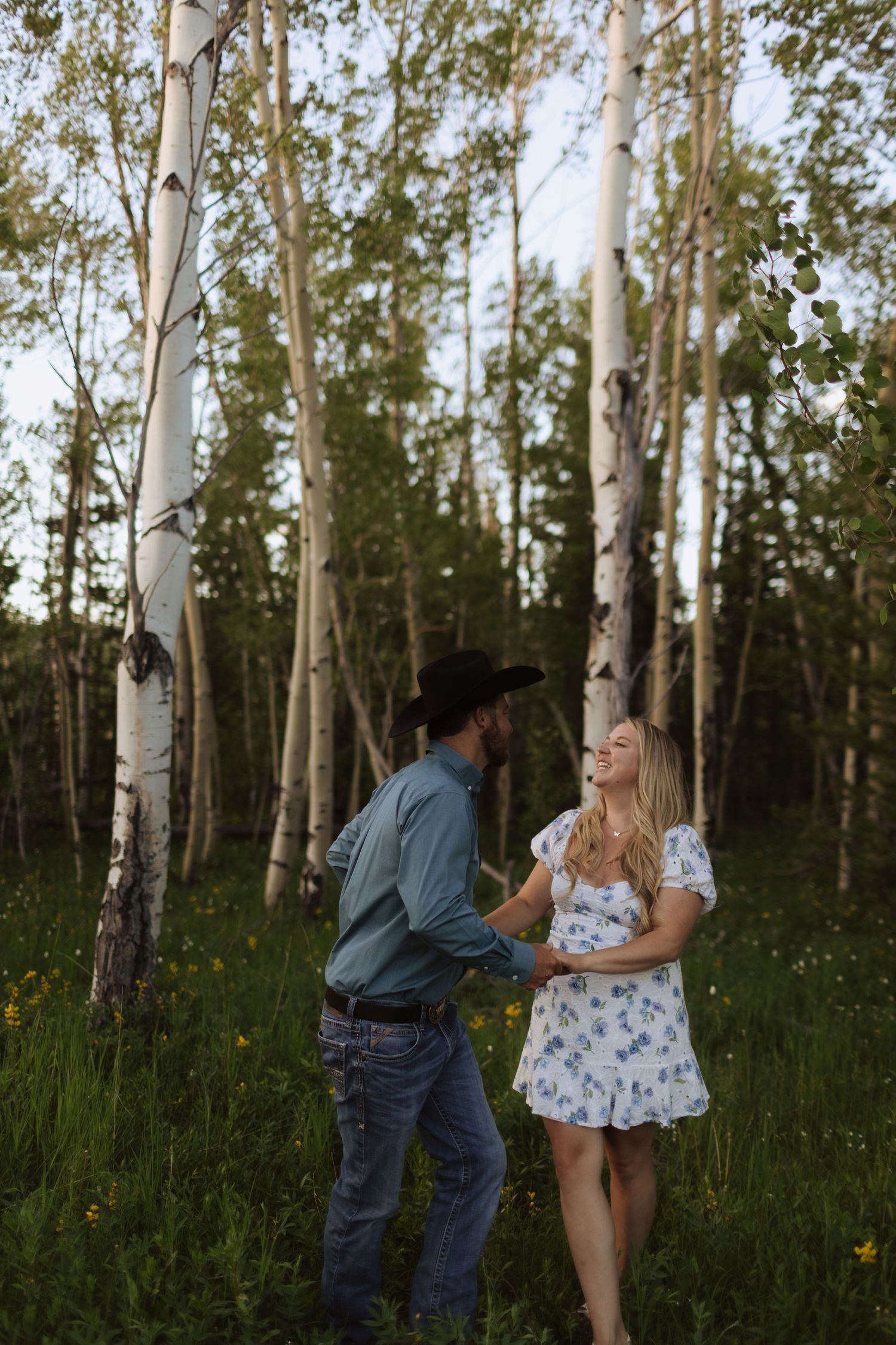 Romantic sequence in a birch forest with couple enjoying playful interactions.