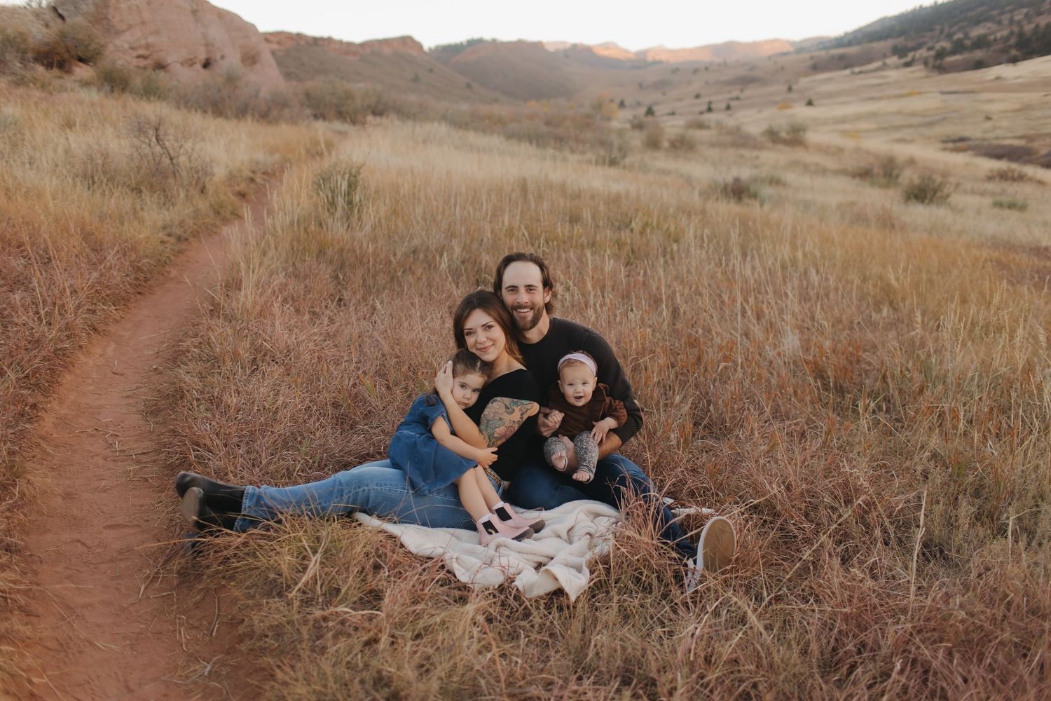 Couple enjoying intimate moments on hiking trail during sunset photo session.