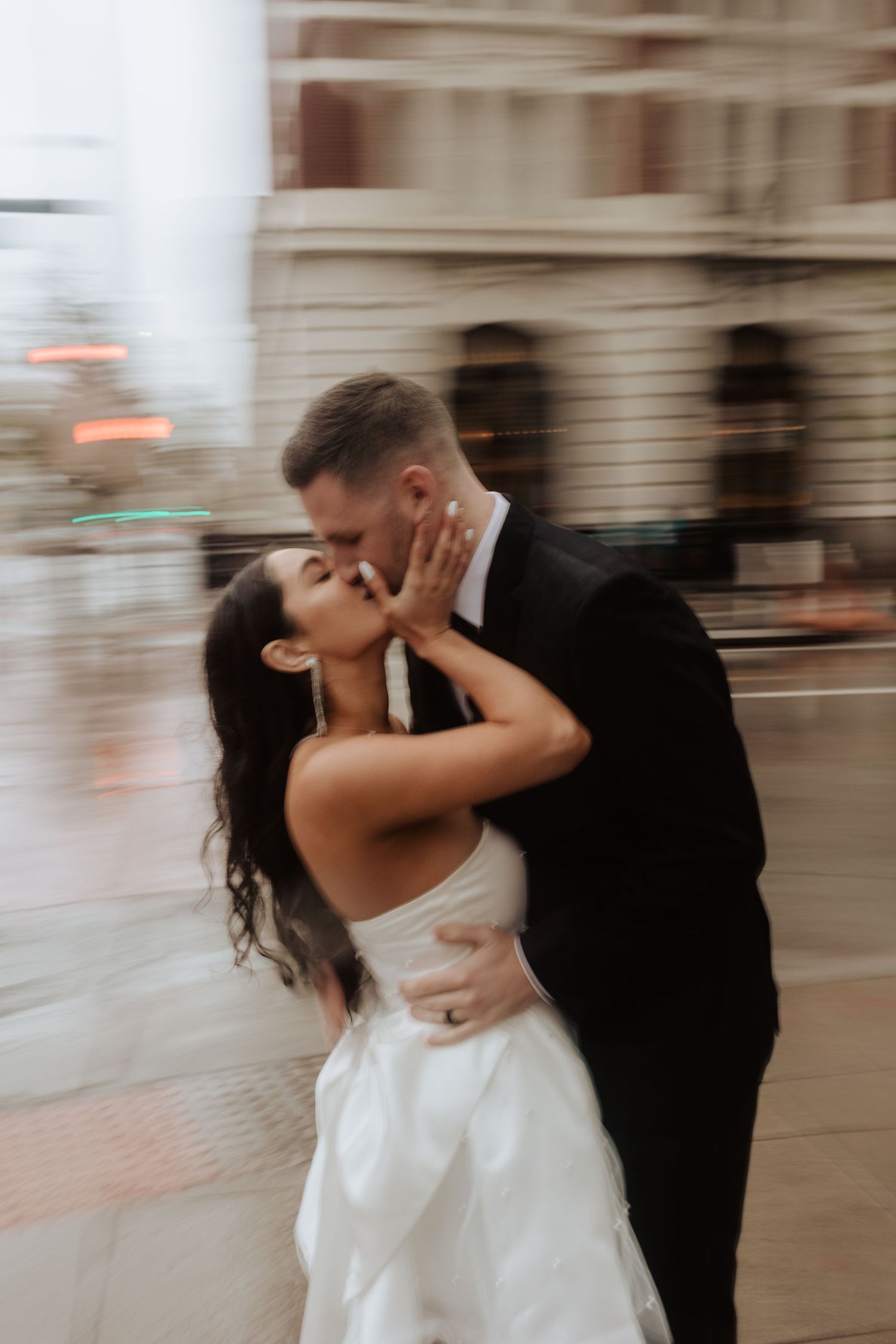Motion-blurred sequence of newlyweds sharing tender moments outdoors.