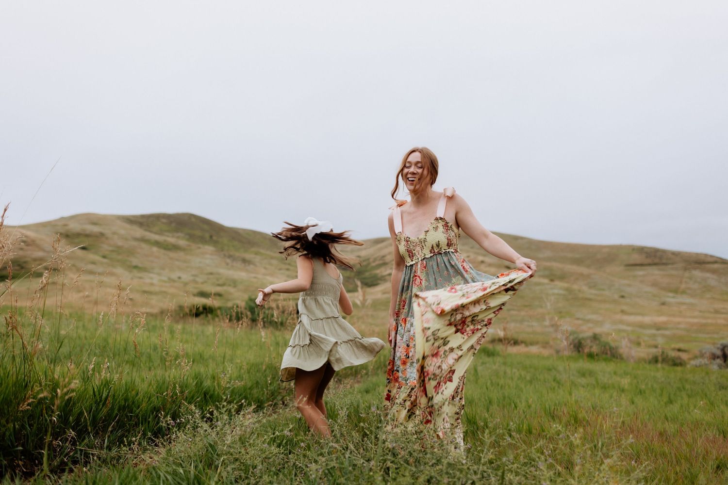 Playful family moments captured against a backdrop of rolling hills and prairie grass.