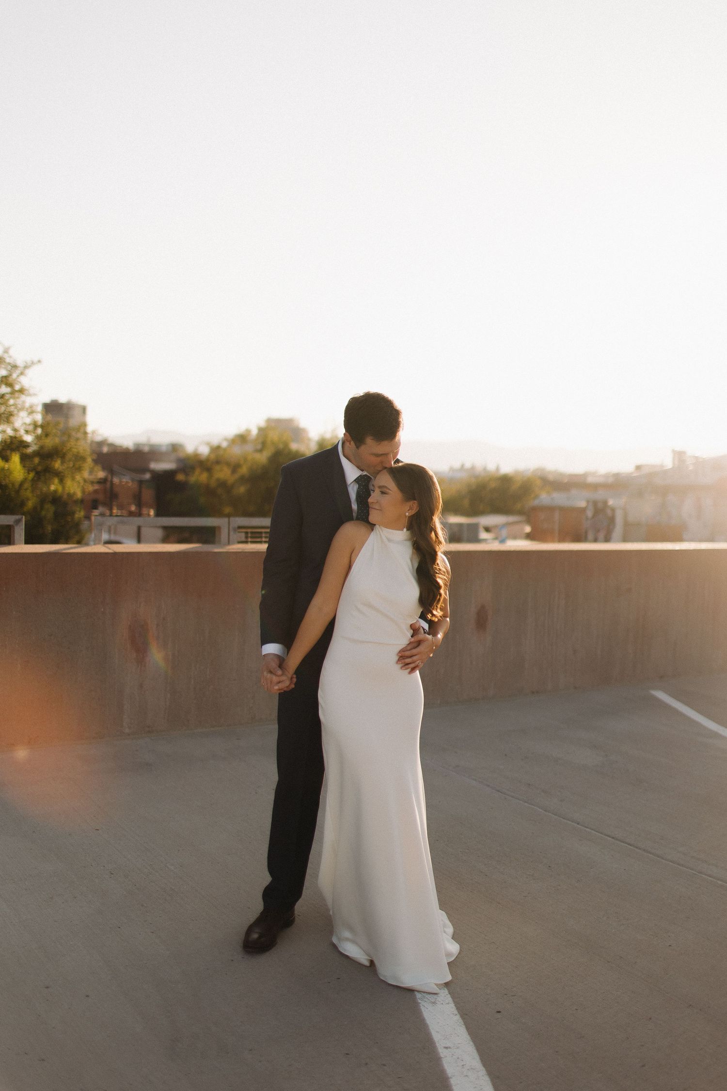 Romantic rooftop wedding portraits at golden hour in urban setting.