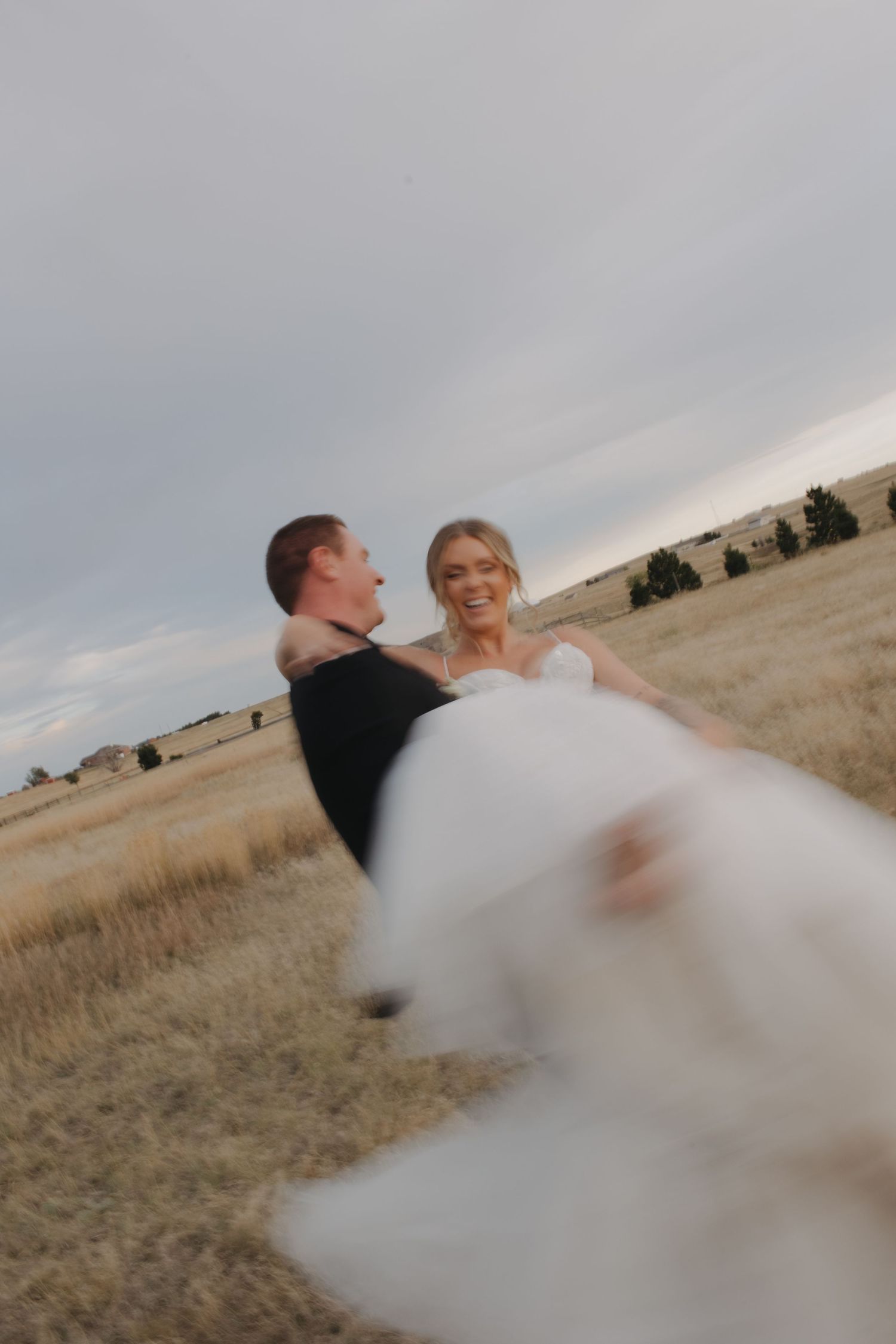 Creative spinning motion wedding photo in a field at sunset.