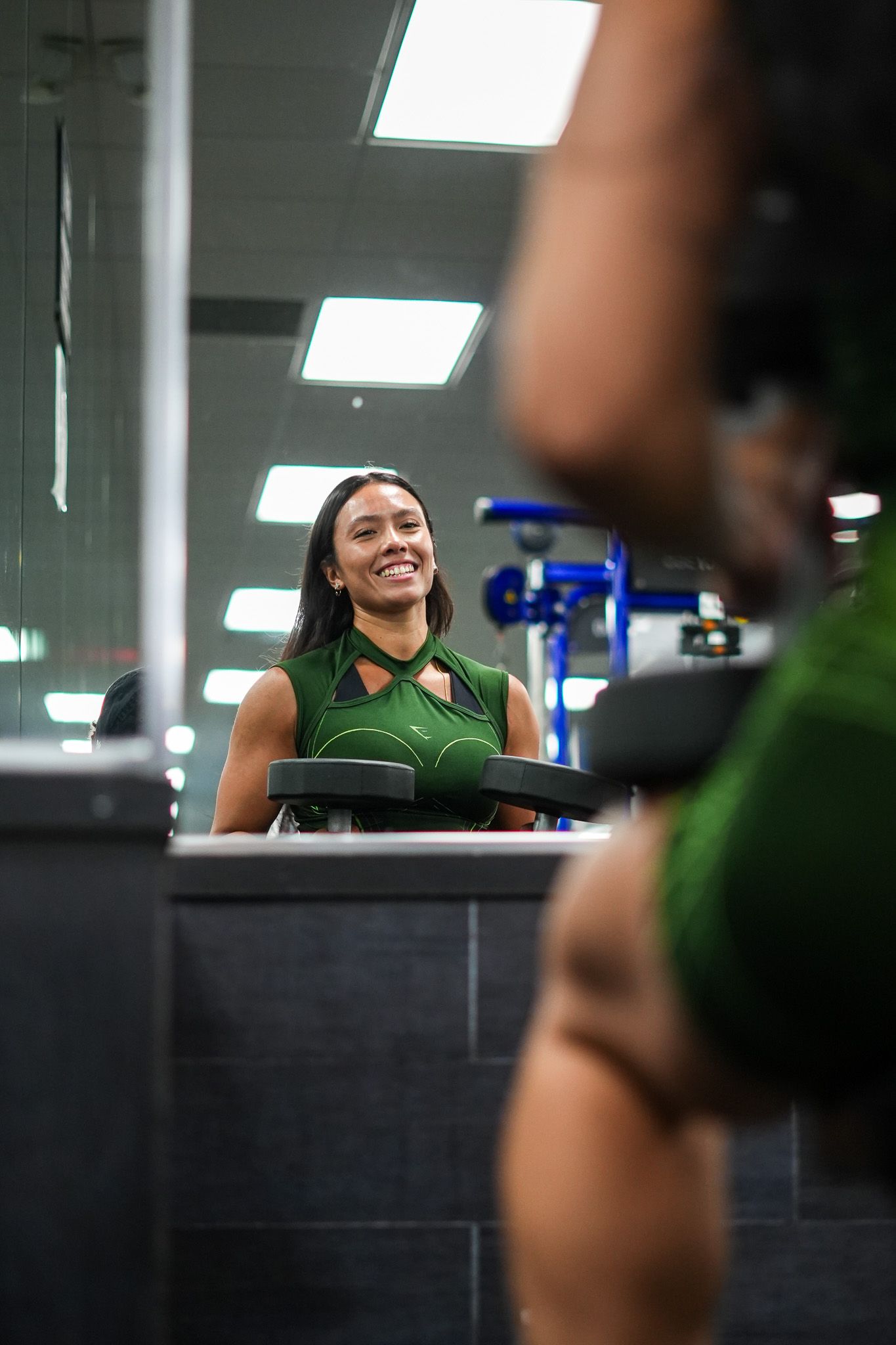 Workout session reflection shown in gym mirror with fitness equipment visible.