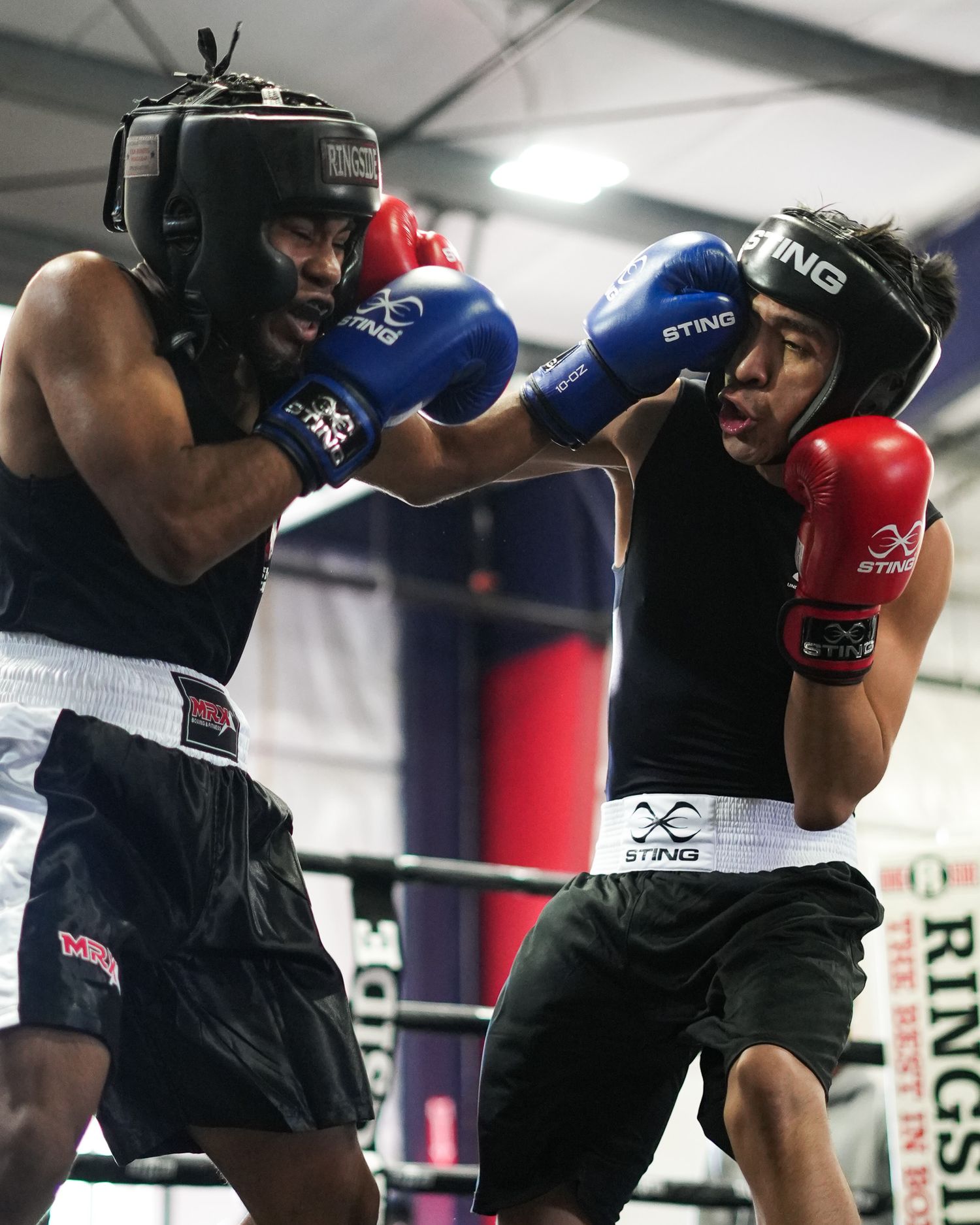Two boxers sparring in protective headgear during a training session.