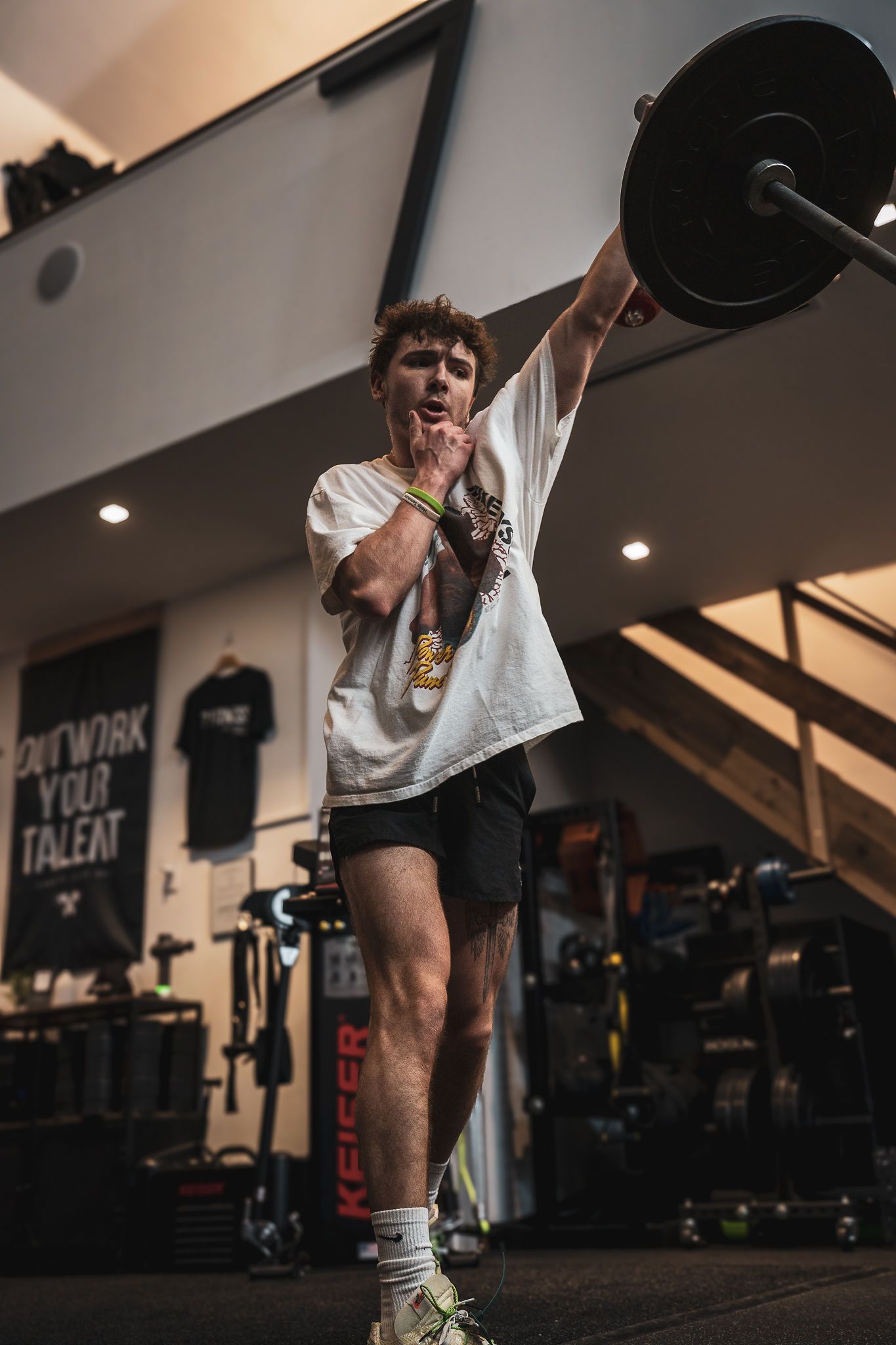Person exercising with weightlifting equipment in a modern fitness facility.