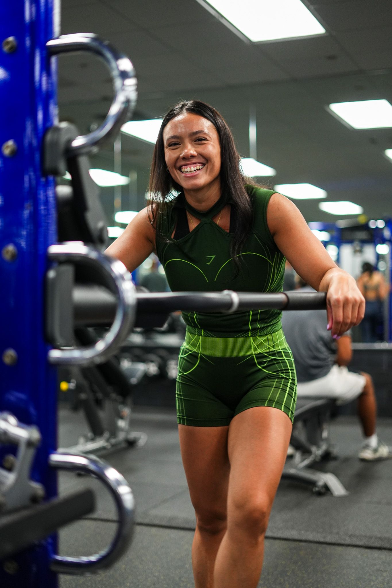 Athletic figure in green workout gear training in modern gym facility.