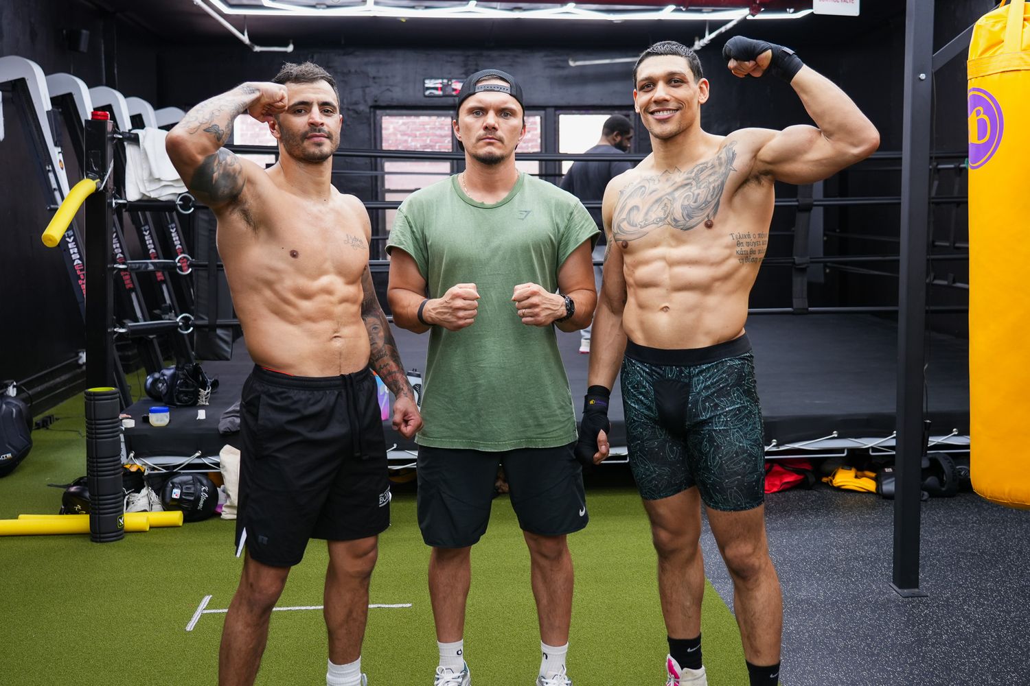 Group of athletes posing together in modern gym with yellow accents.