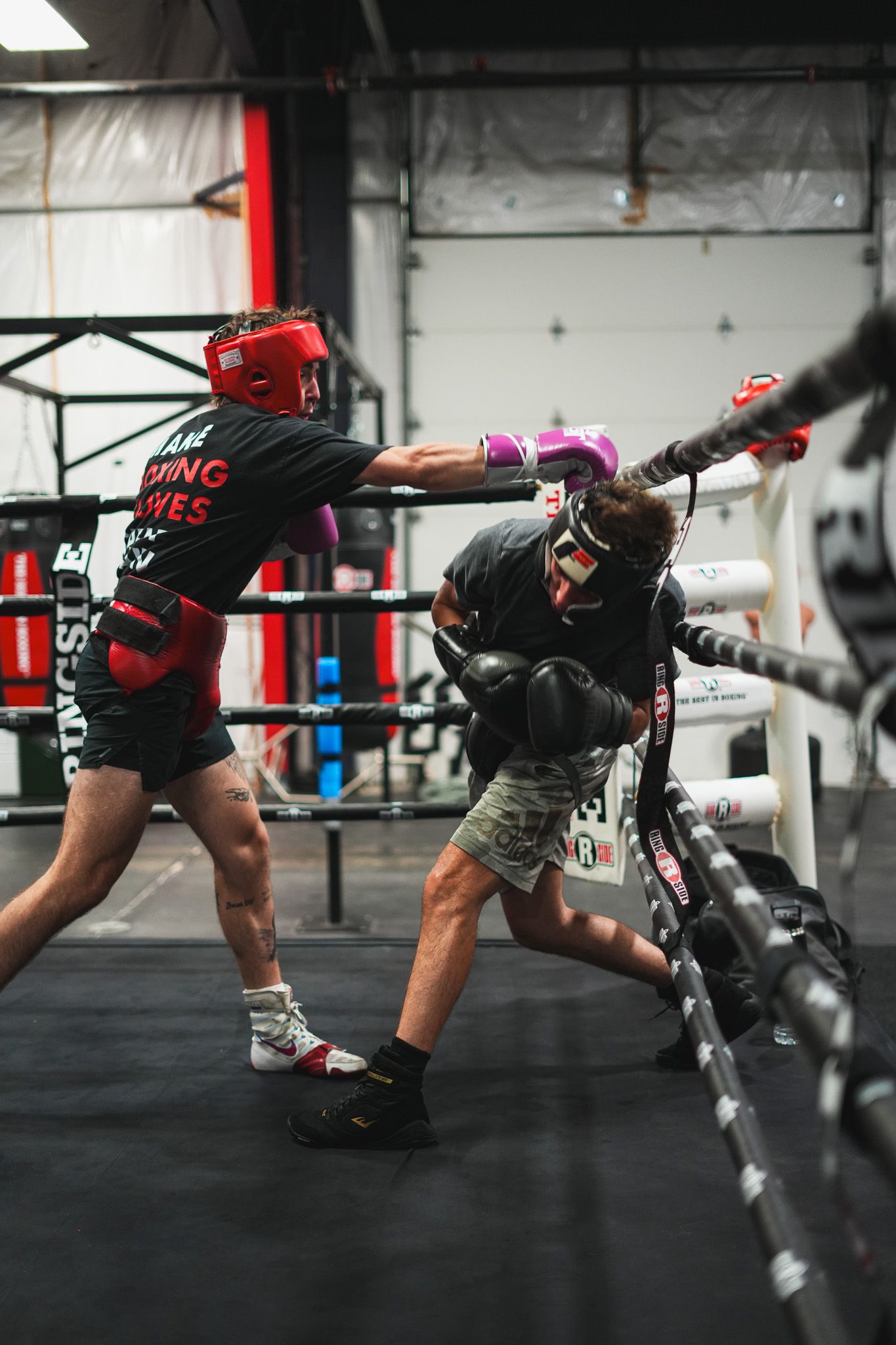 Boxer performs dynamic movement drills along the boxing ring ropes.