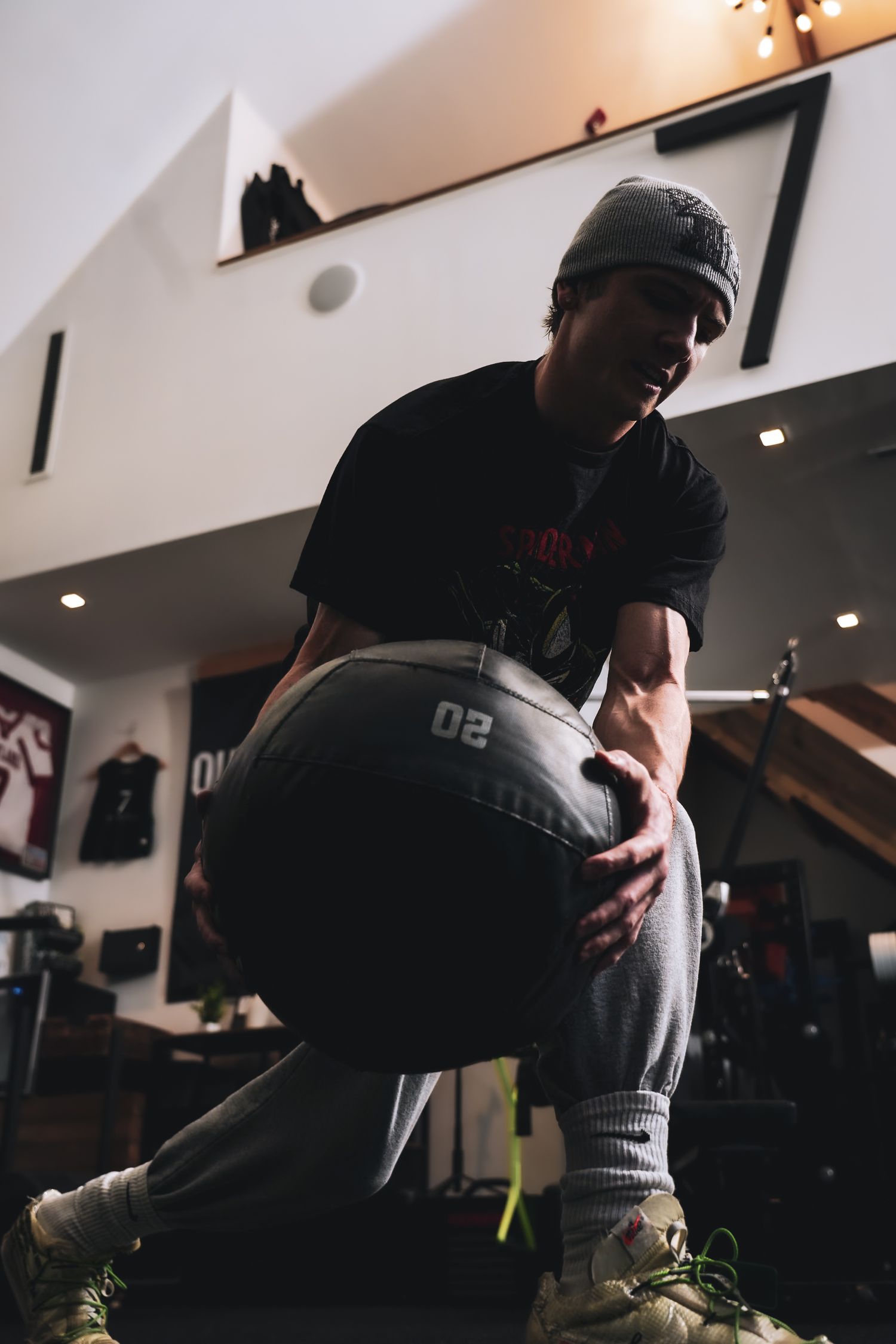 Person practicing boxing combinations with a punching bag in a dimly lit gym setting.