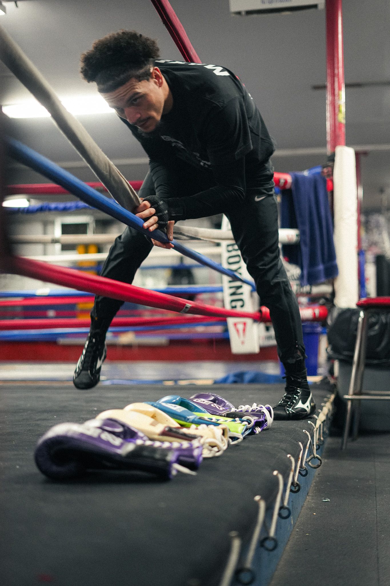 Boxer demonstrates agility drills near the boxing ring ropes.