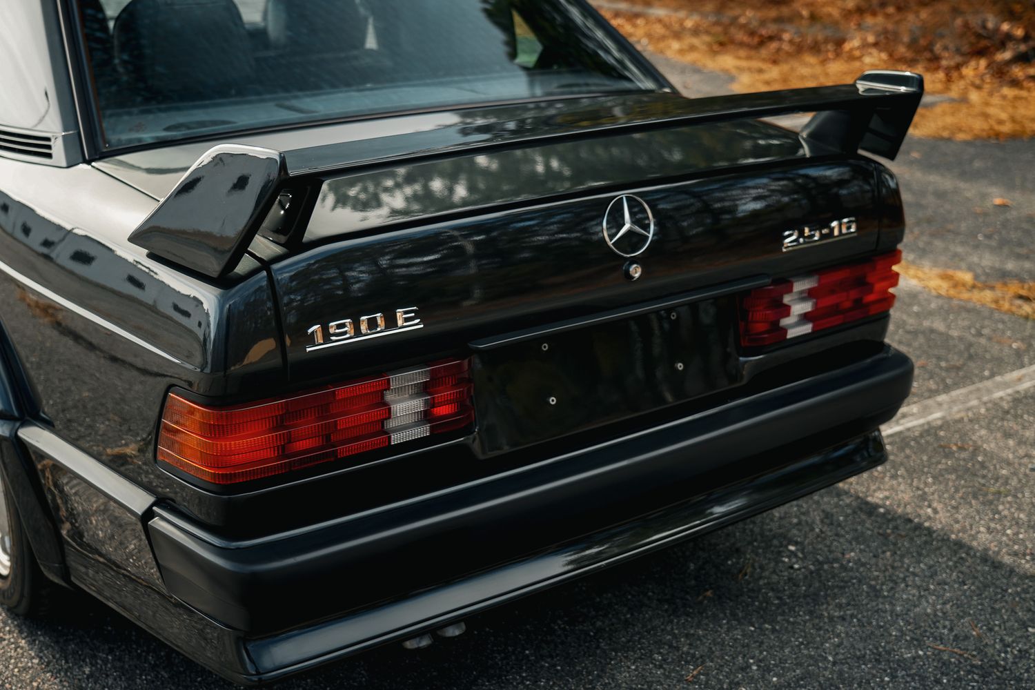 Rear view of black Mercedes-Benz showing classic tail lights and trunk design.
