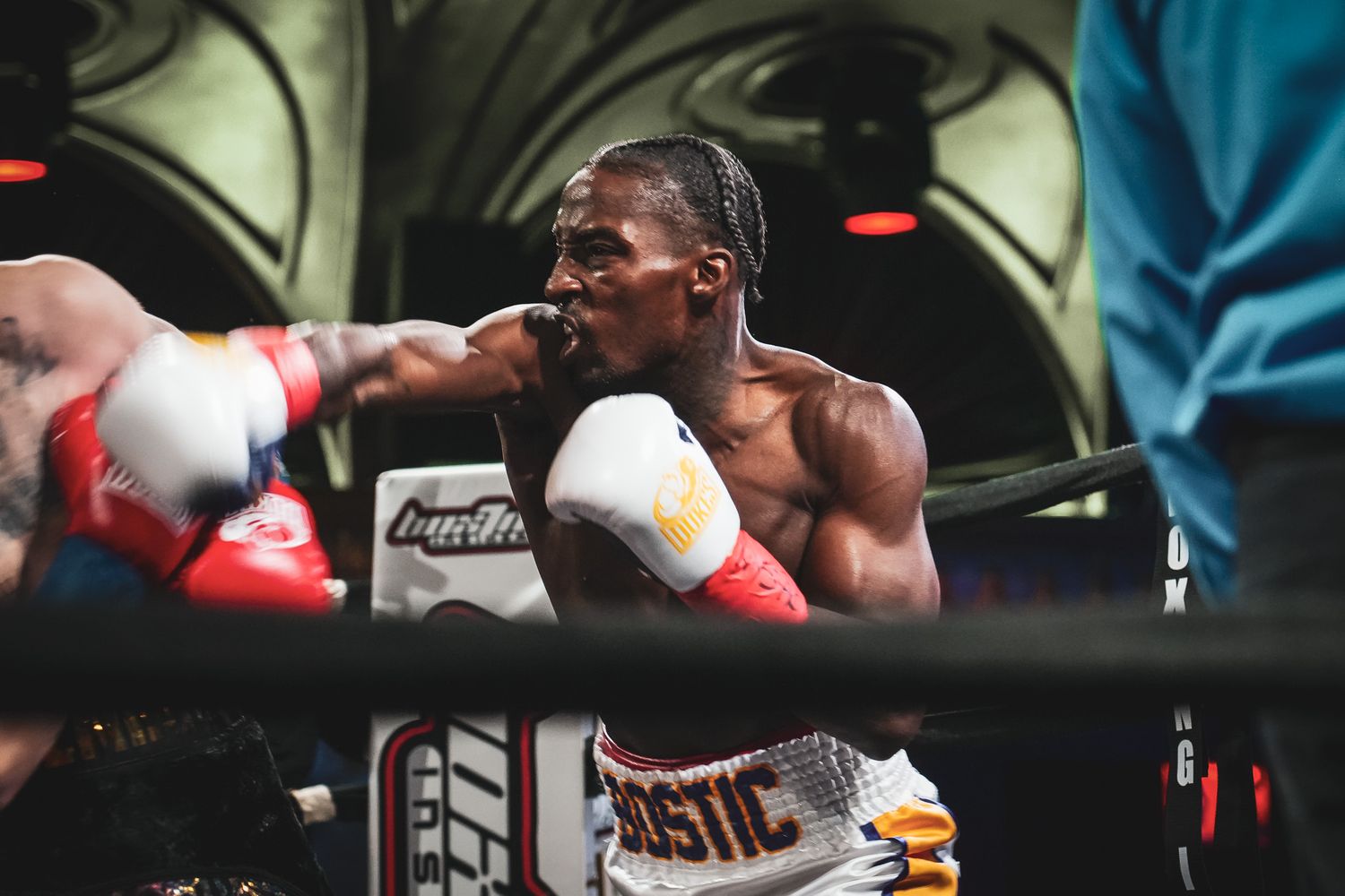 Two boxers sparring in a professional boxing ring during training.
