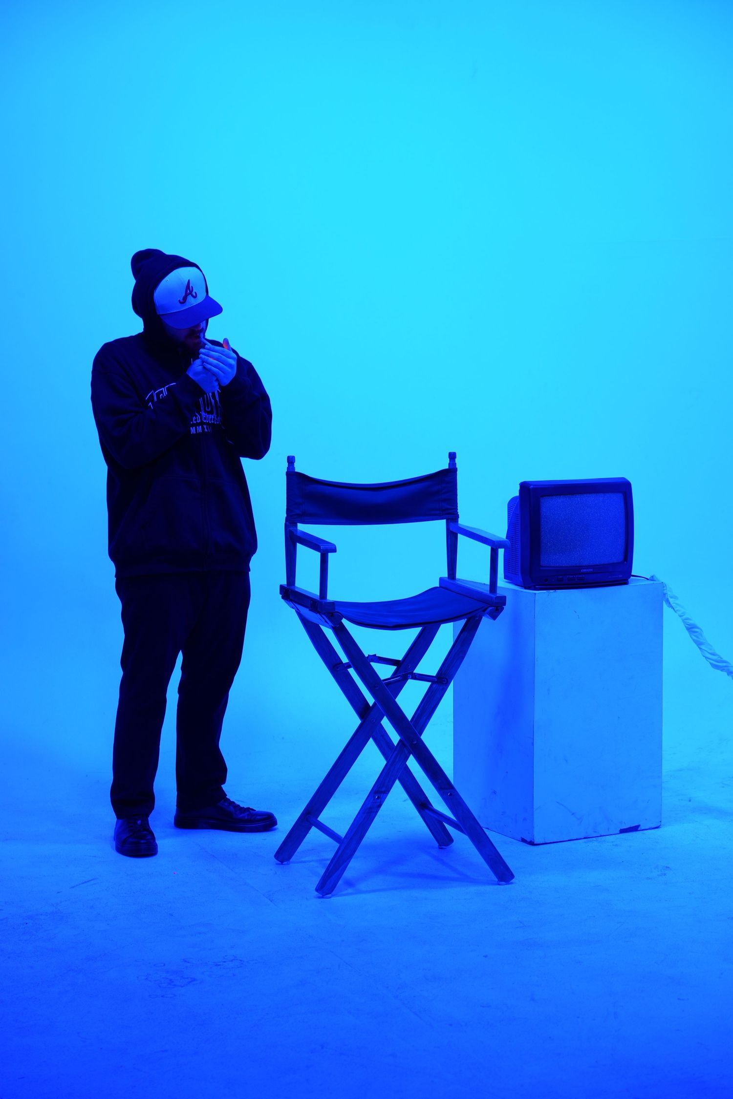 Blue-tinted scene with director's chairs and figure in silhouette.