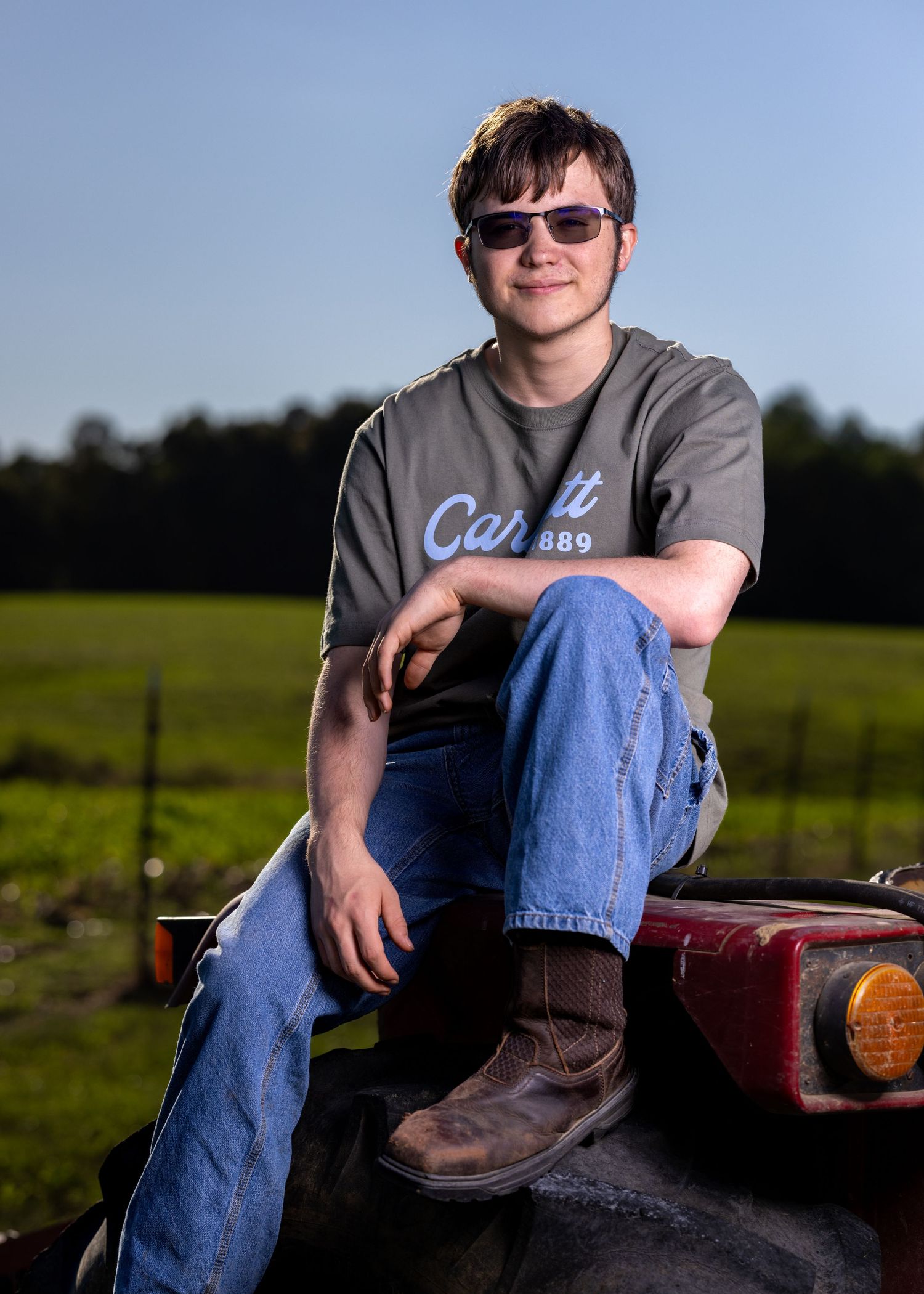 Trent's senior photo. Outdoors with tractor.