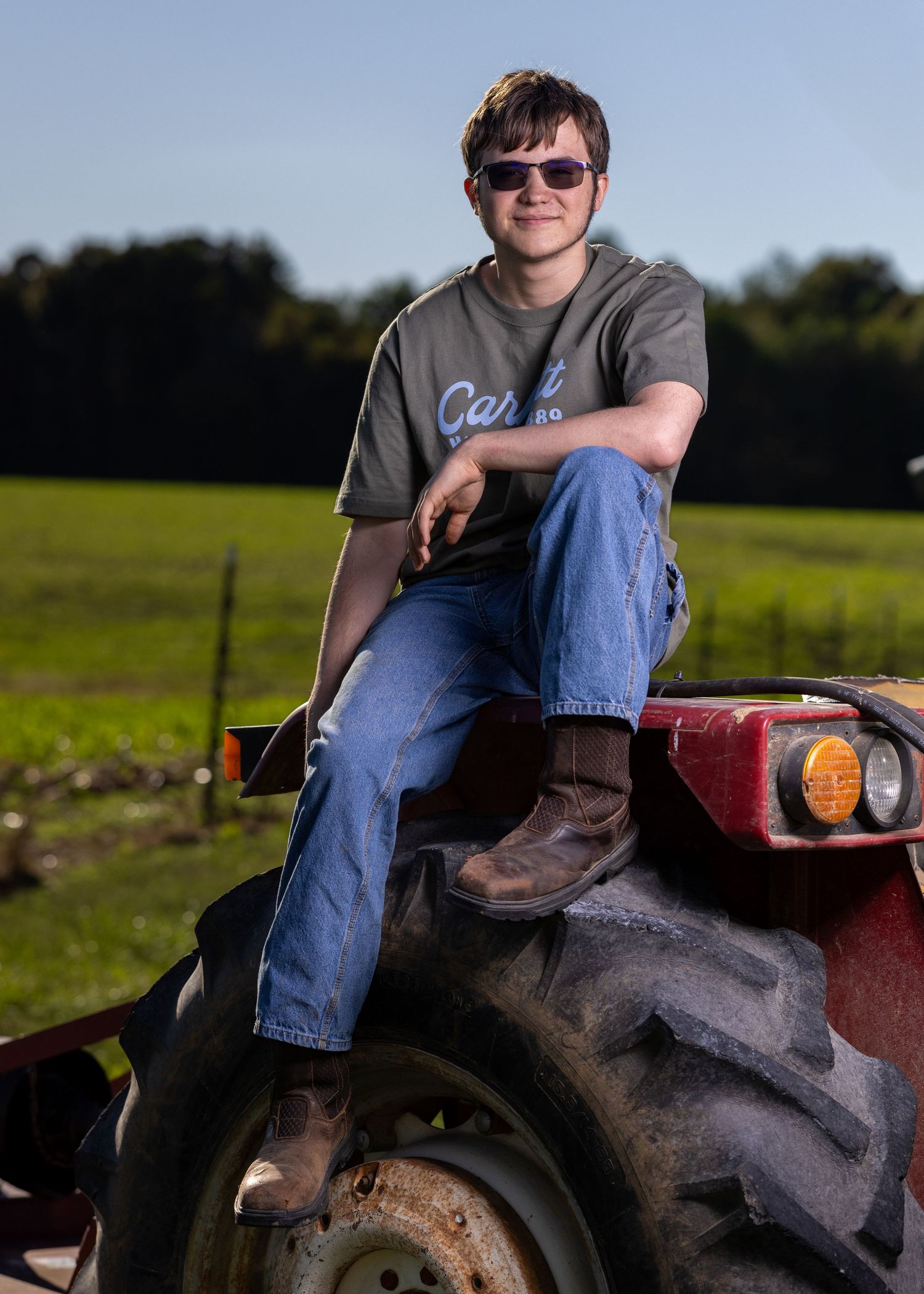 Trent's senior photo. Outdoors with tractor.
