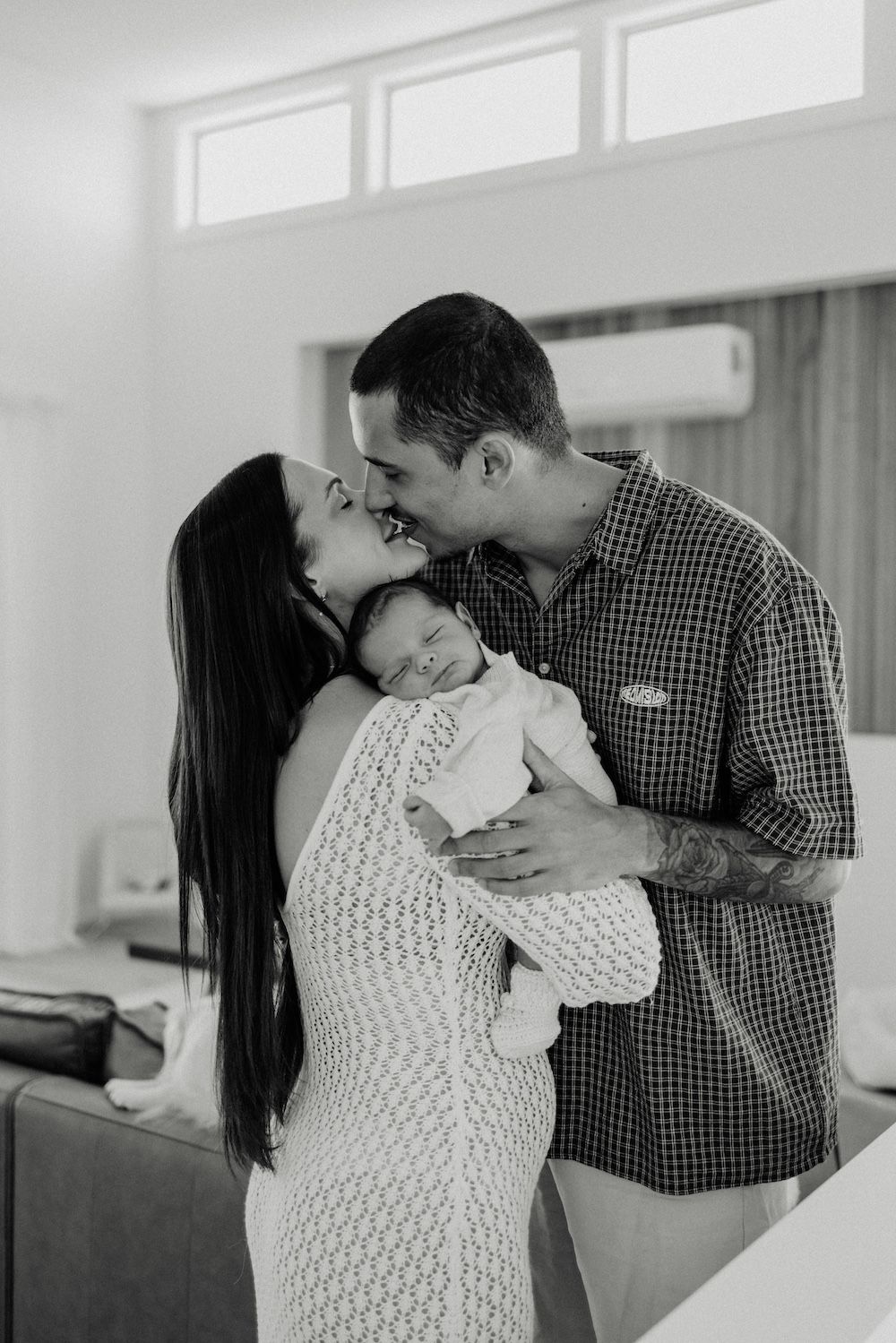 Tender family moment captured in black and white as parents share a loving embrace with their baby. Geelong Melbourne newborn maternity