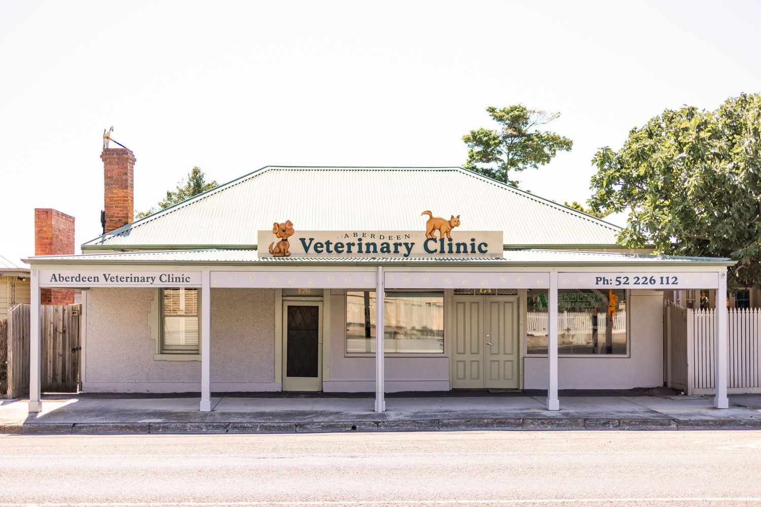 Exterior view of Aberdeen Veterinary Clinic, a charming white building with green roof and covered porch in Australia.