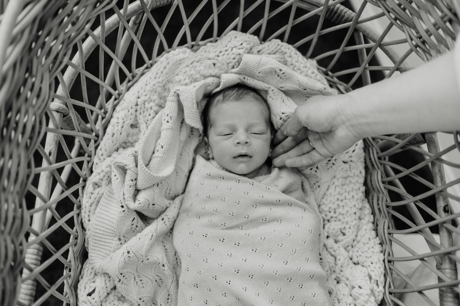 A serene nursery scene with a couple standing barefoot beside a white crib.