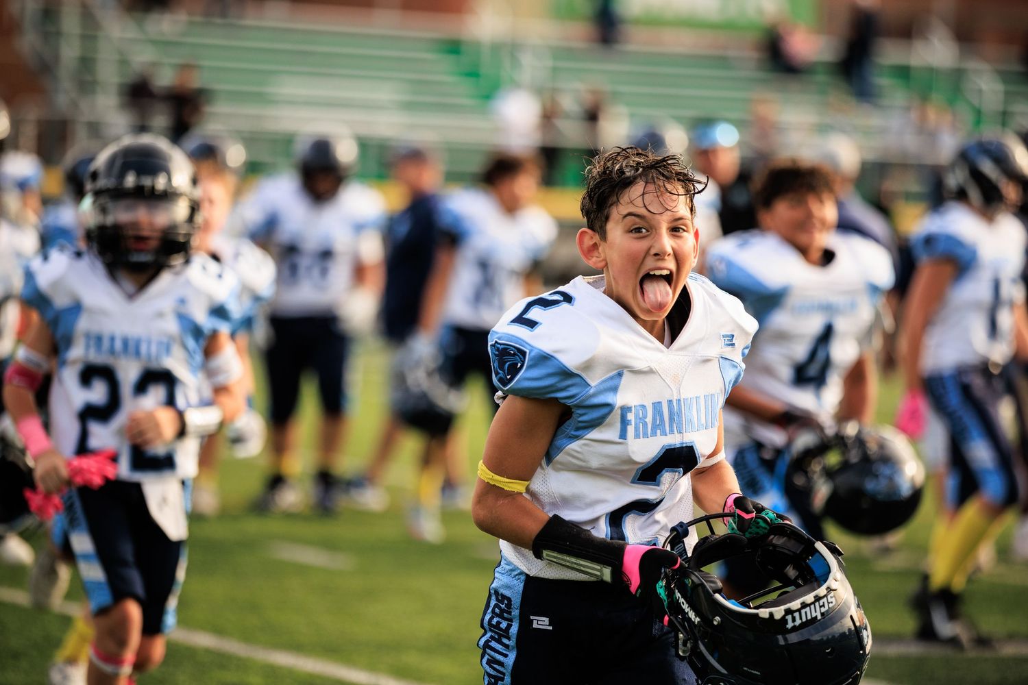 Excited youth football player in Franklin uniform celebrating on field during a game.